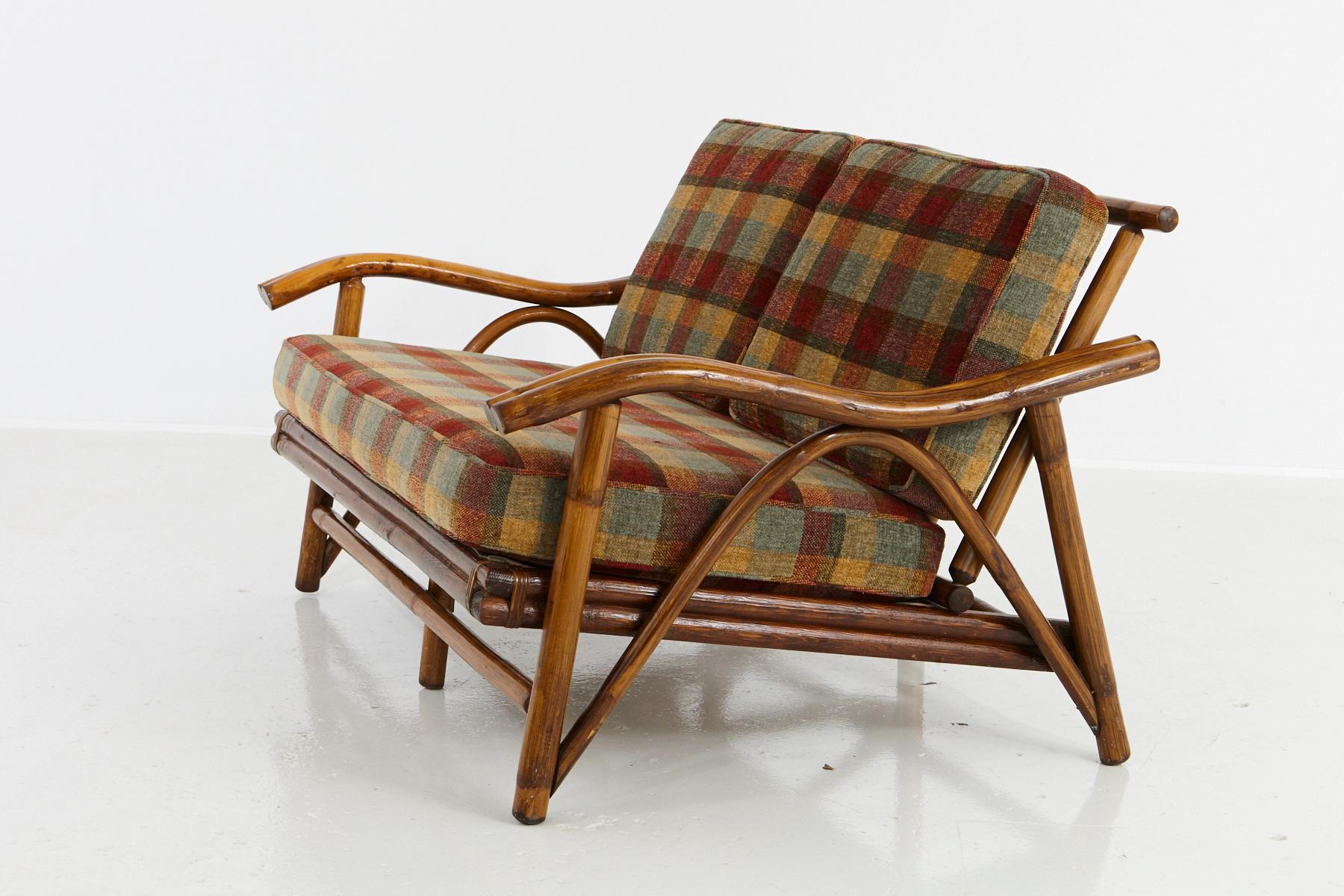 Vintage settee/loveseat with serpentine arms, in the style of John Wisner for Ficks Reed, 1950s.
Very well executed rattan and hardwood construction, with spring support, beautiful textured and colored cushions in very good condition.
The