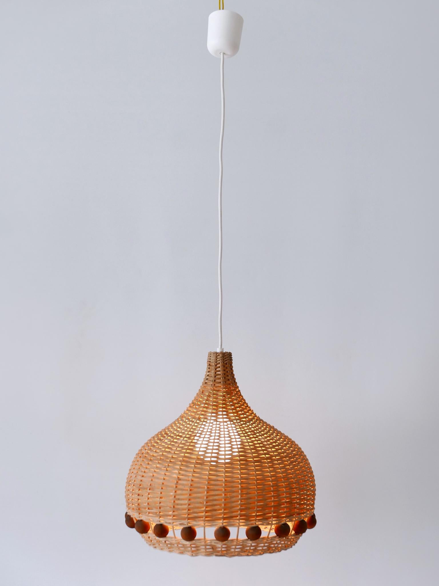 Lovely & highly decorative Mid-Century Modern rattan tulip pendant lamp or hanging light. Designed & manufactured in Germany, 1960s.

Executed in rattan and wood ball elements, the pendant lamp comes with 1 x E27 / E26 Edison screw fit bulb socket,