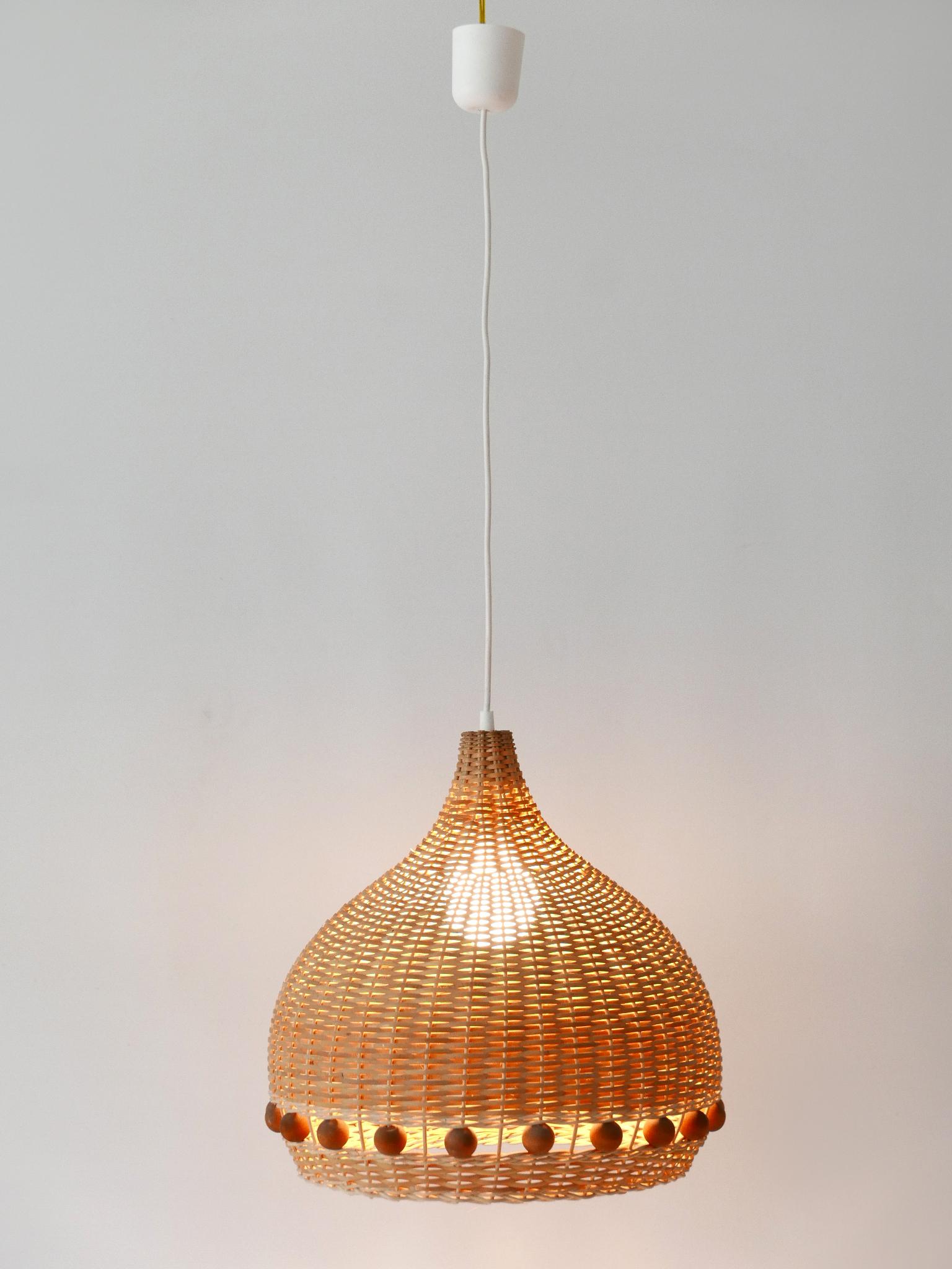 Lovely & highly decorative Mid-Century Modern rattan tulip pendant lamps or hanging lights. Designed & manufactured in Germany, 1960s.

12 identical lamps are available. Price per piece.

Executed in rattan and wood ball elements, the pendant lamp