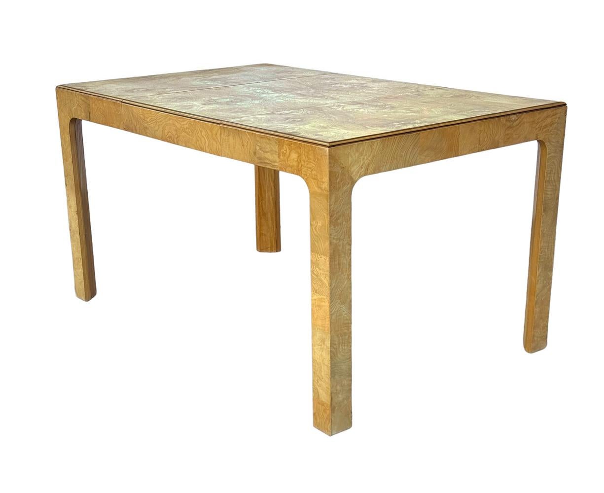 A classic, simple, and modern design for the 1960s. This table features beautiful burl wood in a book matched symmetrical design. Table comes with one 20 inch extension leaf as shown.
