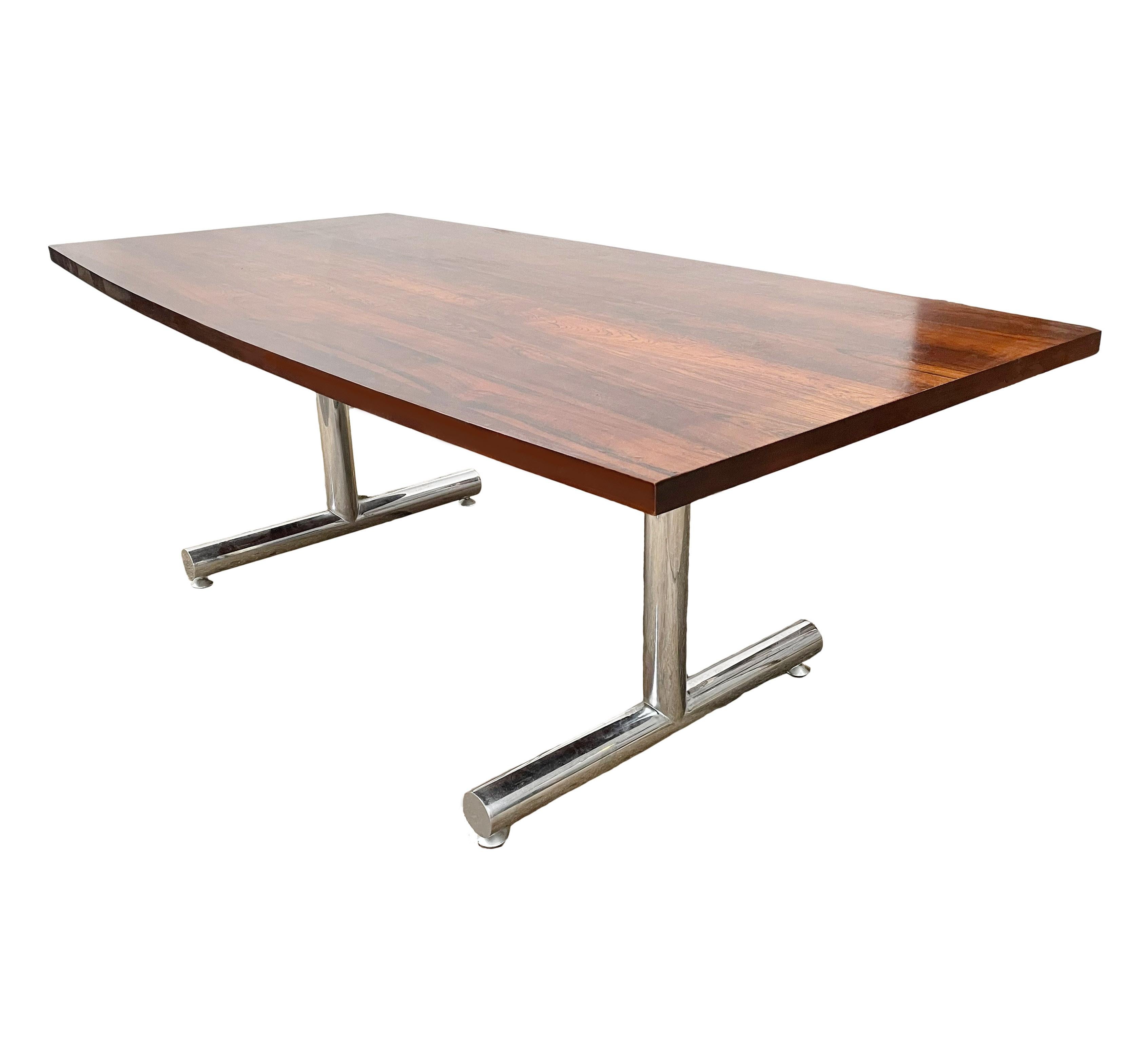 A beautiful clean line design from the 1970s. This table consists of a rectangular rosewood top with bowed sides, and thick tubular chrome legs. Clean and ready to use condition.