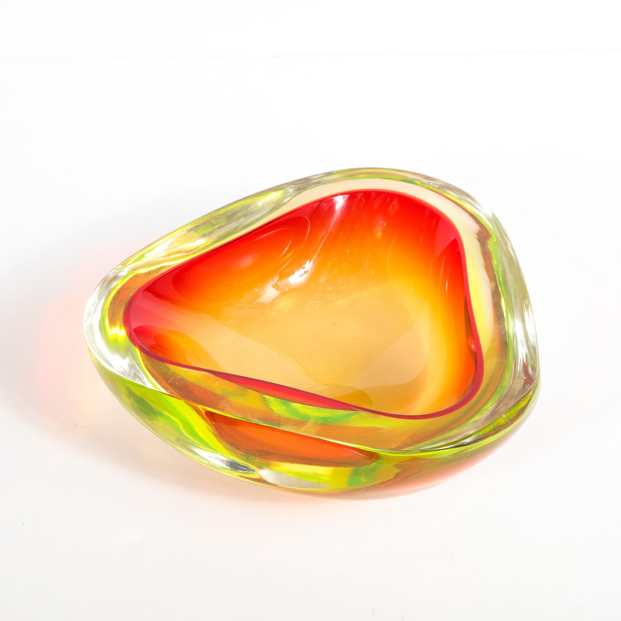 This elegant Mid-Century Modern glass vase bowl realized in Murano, Italy- the island off the coast of Venice renowned for centuries for its superlative glass production- circa 1950. It features a three sided form with rounded corners. The interior