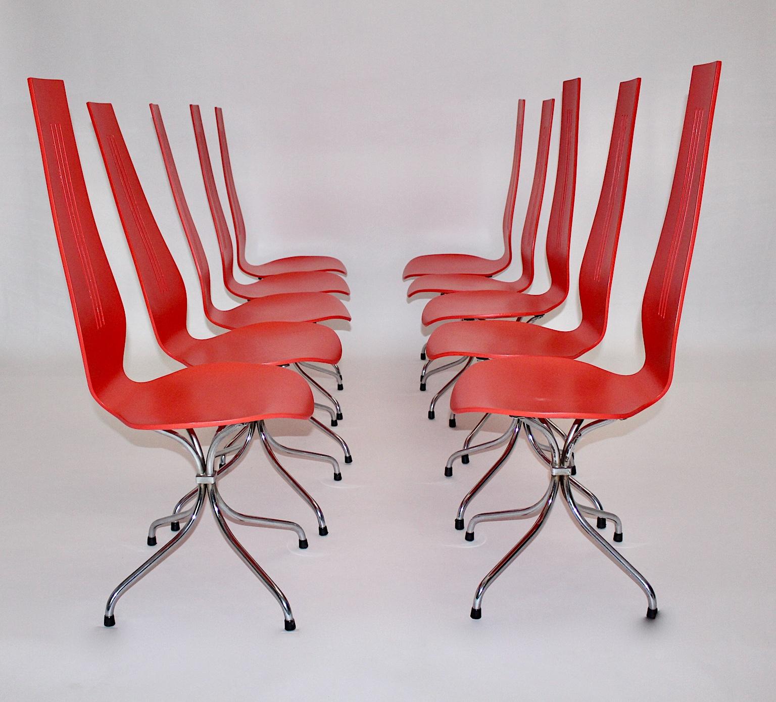 Mid Century Modern vintage dining chairs model chaise lyre by Theo Häberli 1960s.
The rare set of 10 vintage dining chairs show red lacquered plywood seats and chromed metal feet with black rubber sabots. 
The vintage dining chairs are characterized