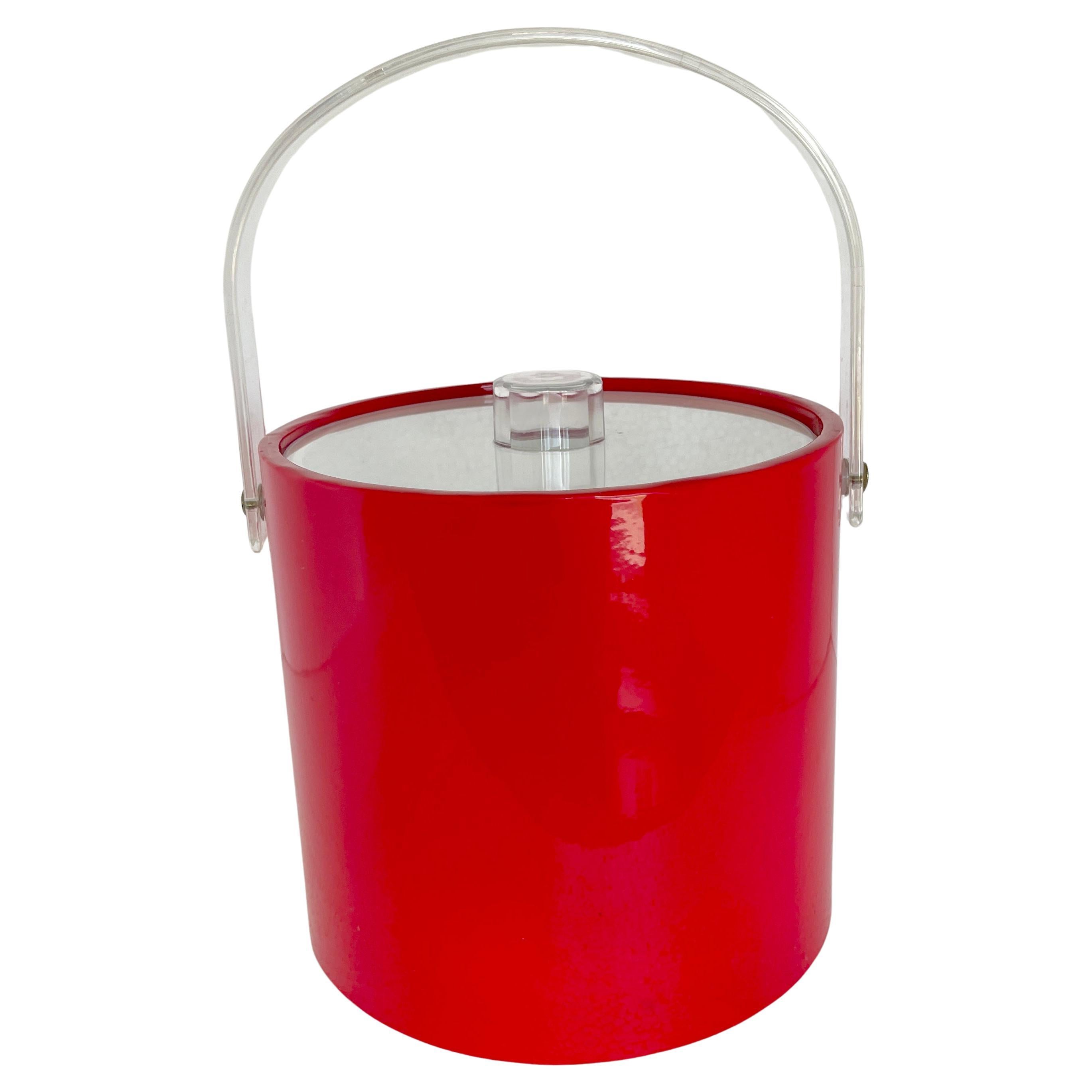 Mid-Century Modern ice bucket. Shiny red faux leather exterior with white interior; solid and fully functional ice bucket. The acrylic handle and lid are classic mid-century modern design elements. The ice bucket is bright and happy and is a welcome