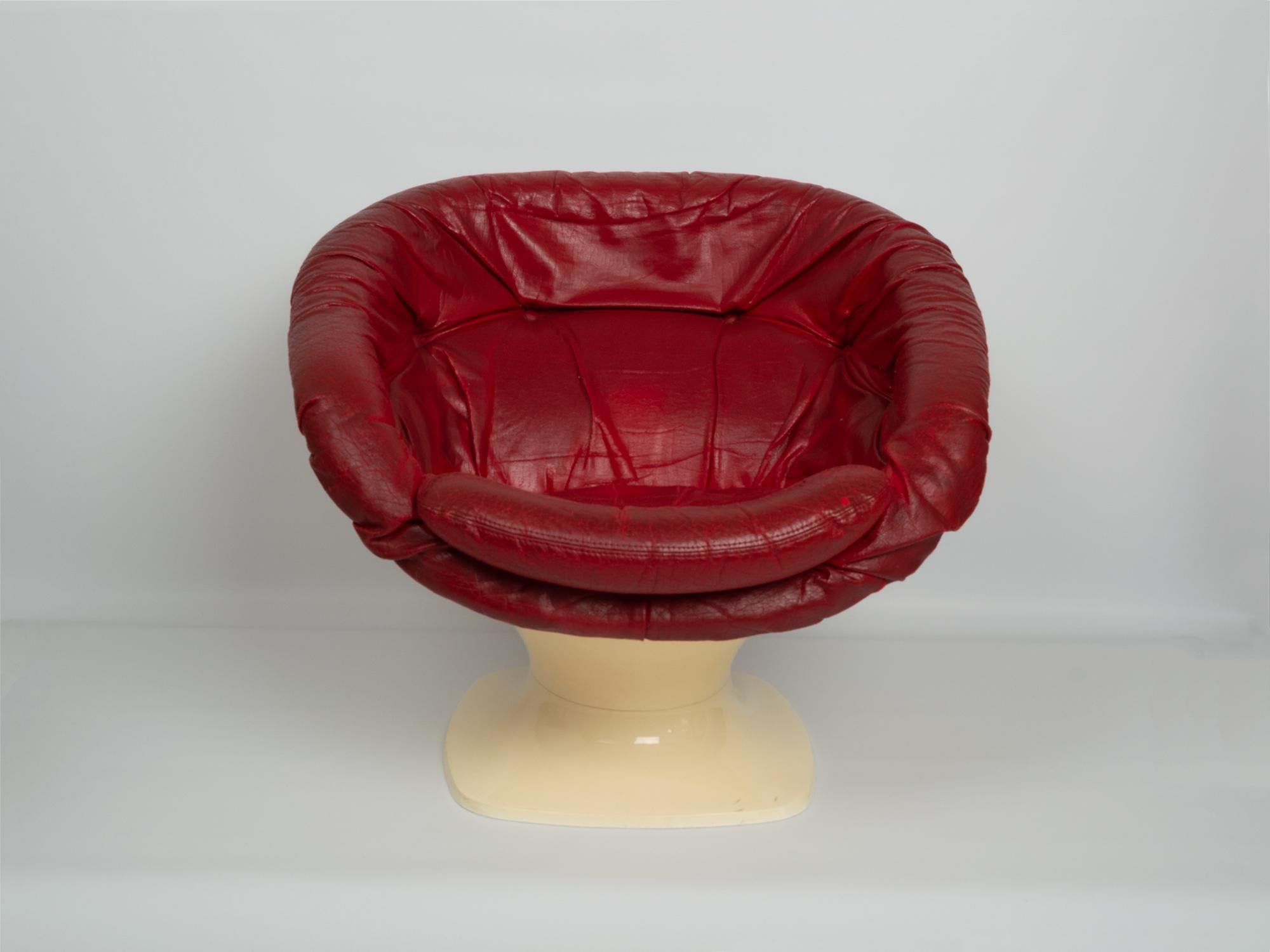 A Mid-Century Modern space age club chair by Raphael Raffel, France 1965.

The club chair features a tulip form with a rounded seat, covered in its original red leather upholstery. 

The plastic base in very good condition, and the leather