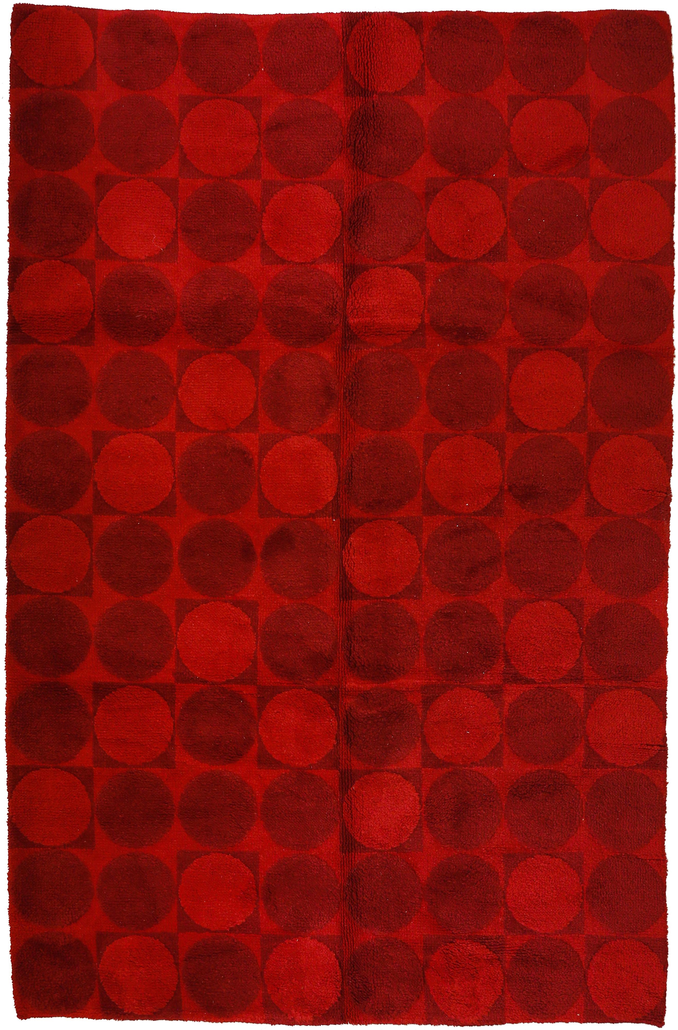 An unusual hand-knotted carpet woven in two tones of red, with an all-over pattern of perfectly executed roundels. Patterns such as this one were clearly influenced by Op-Art designers such as Verner Panton, who created an entire collection based on