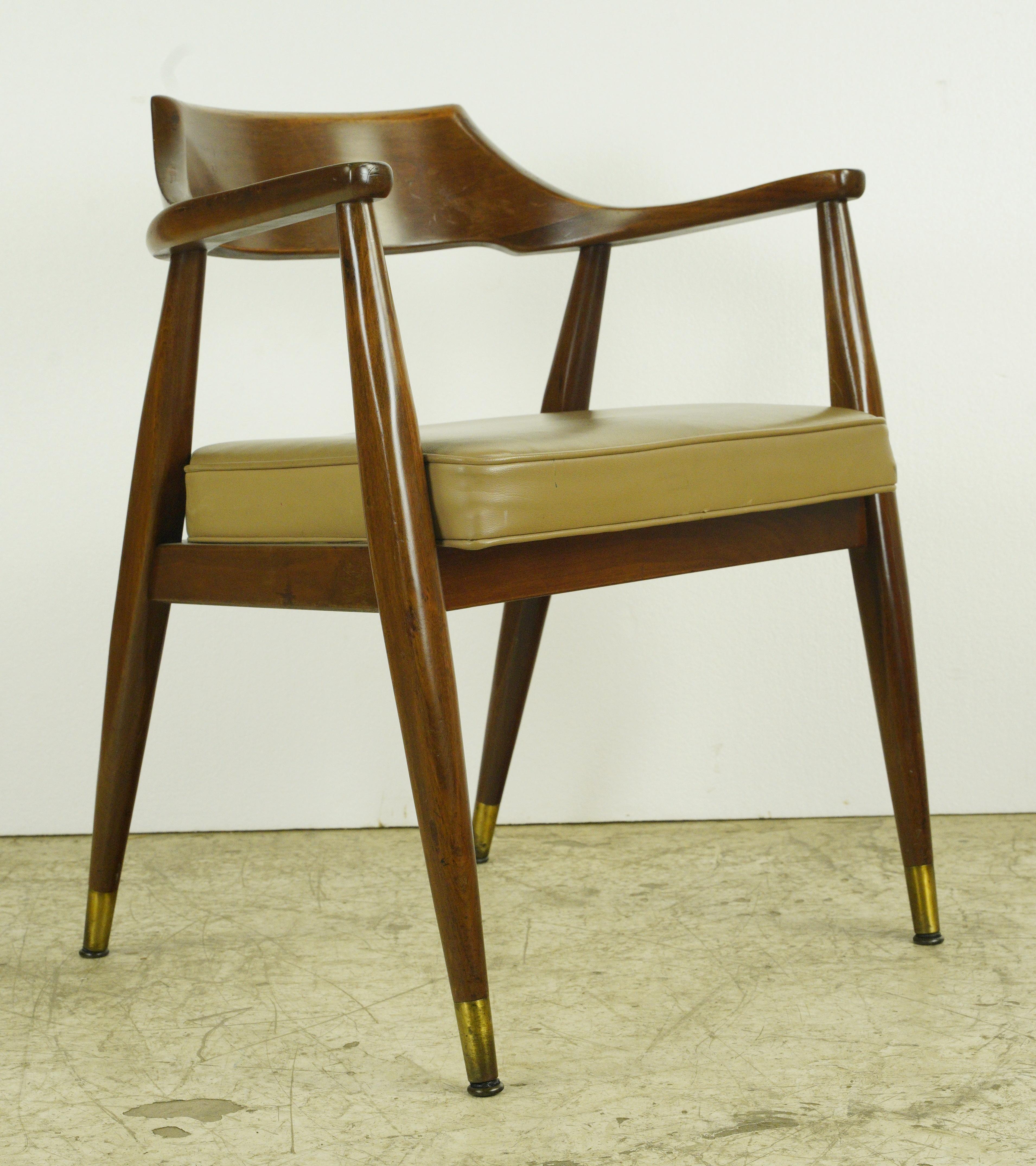 This Mid-Century Modern armchair is made of chestnut wood, a tan leather seat, and brass hardware. Made by Regan Furniture Corp. Good condition with appropriate wear from age. One available. Please note, this item is located in our Scranton, PA
