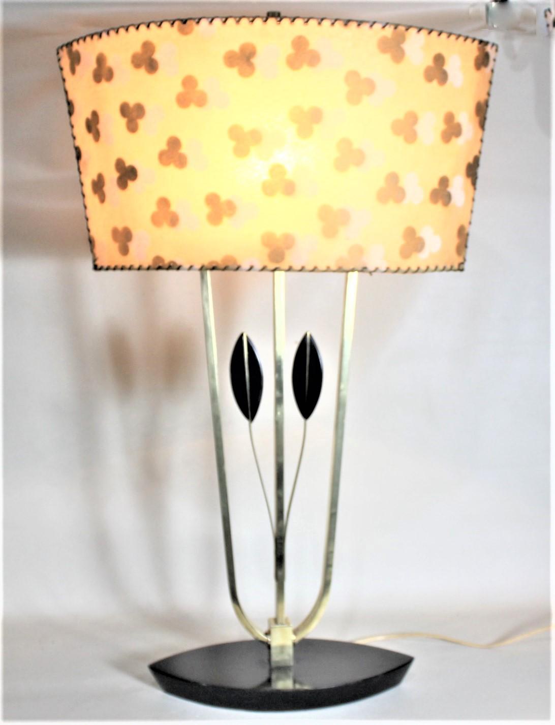 This Mid-Century Modern table lamp is unsigned but consistent with the lamps produced by the Rembrandt Lamp Company of the United States in circa 1965. The lamp is composed of solid brass and wood which has a lacquered black contrasting finish and a