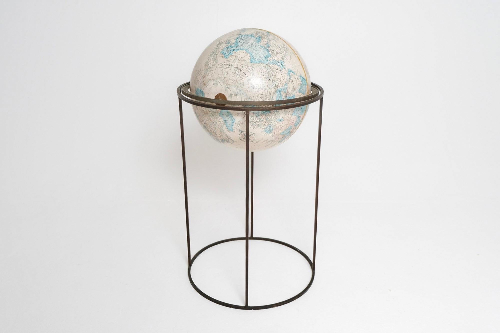 A rare and iconic mid-century globe designed by Paul McCobb for his Planner Group line, manufactured by Replogle and presented on its original minimalist iron stand. This 16-inch diameter “World Classic Series” globe is held aloft by McCobb’s