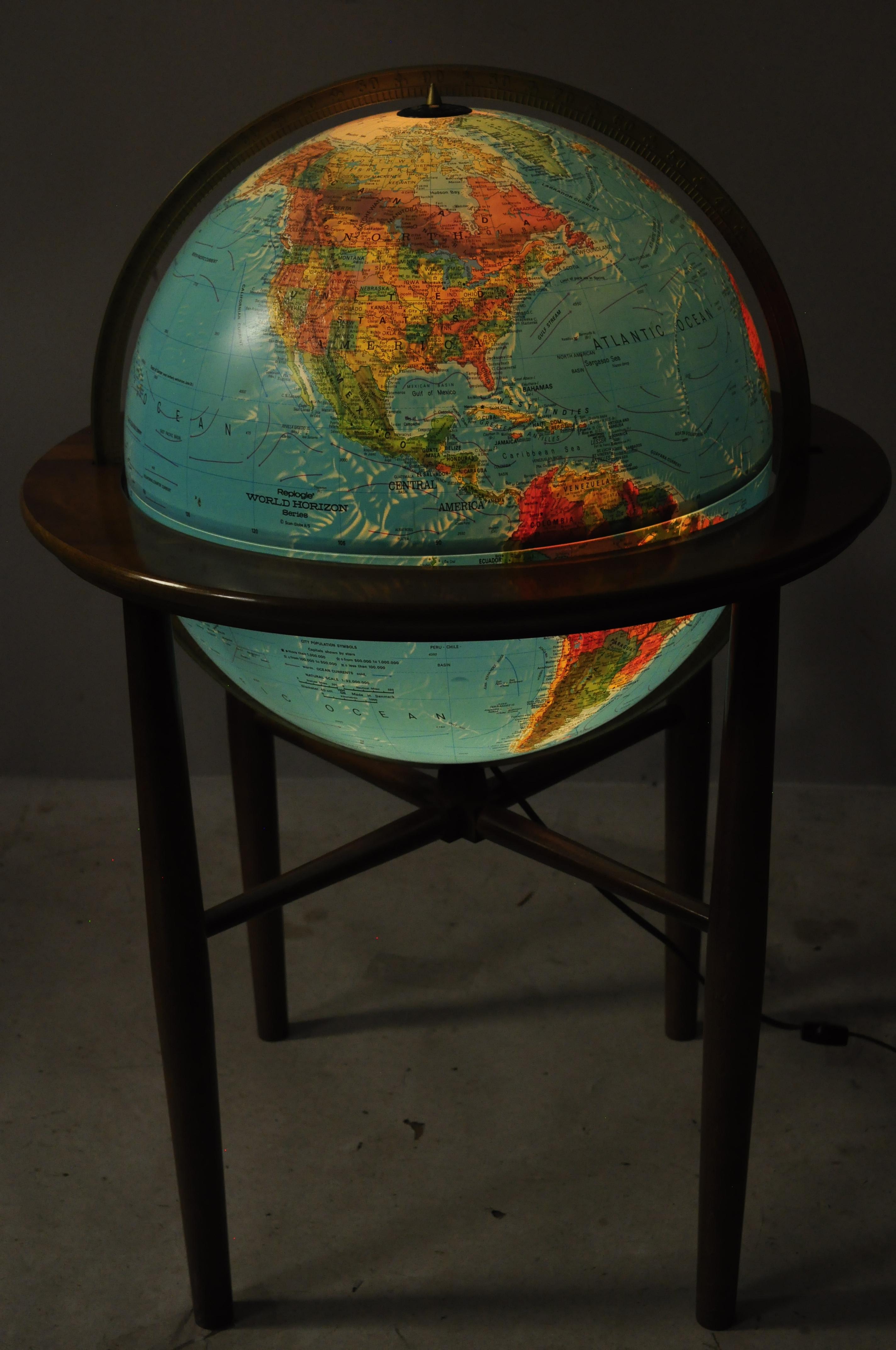 Vintage Mid-Century Modern Replogle Illuminated floor globe on wooden base stand. Item features solid wood frame, beautiful wood grain, lighted interior, tapered legs, clean modernist lines, quality American craftsmanship, great style and form,