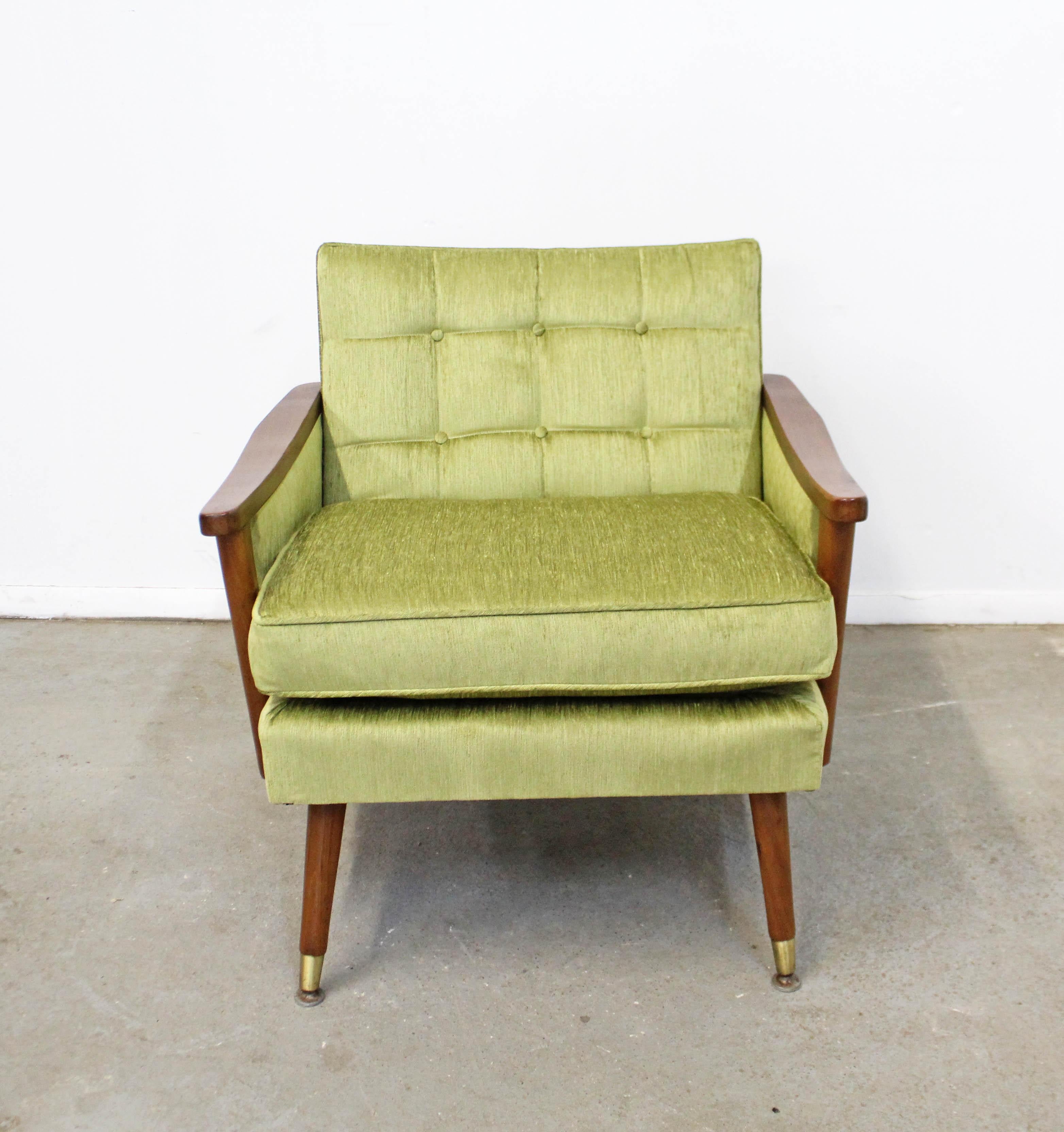 Offered is a beautifully restored vintage Mid-Century Modern lounge chair. This chair has been reupholstered with velvet 'Pear' fabric and has walnut arms and legs with brass feet. There are some minor scratches on the wood and wear on the brass
