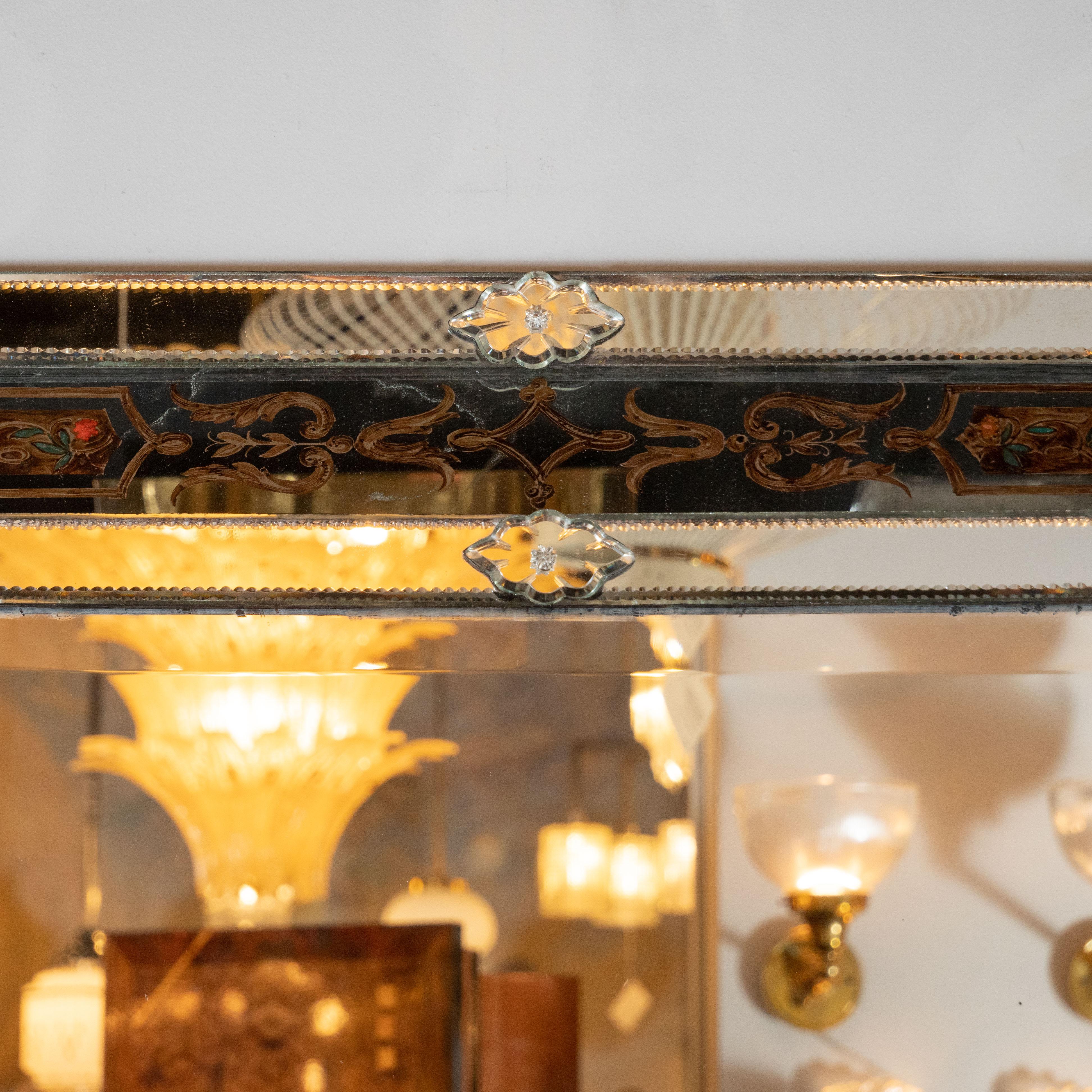 This exquisite Mid-Century Modern shadowbox mirror was realized in France, circa 1950. It features a raised exterior secured at each corner by stylized floral rosettes and chain bevel detailing circumscribing the top and bottom edge. The raised