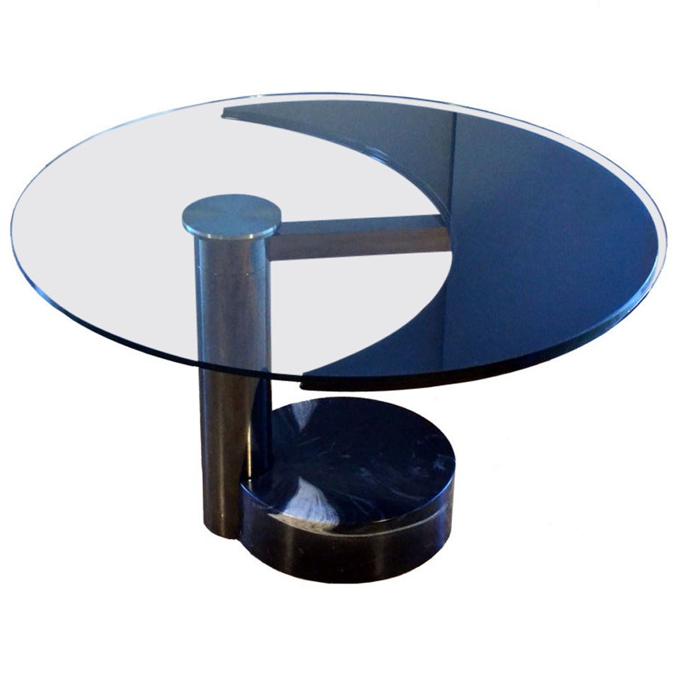 Sculptural dining table revolves in two positions from oval to round. This most exciting table is made with high quality materials and engineering, avantgarde design typical from the 1980's. When the black lacquered moon shape part of the table top