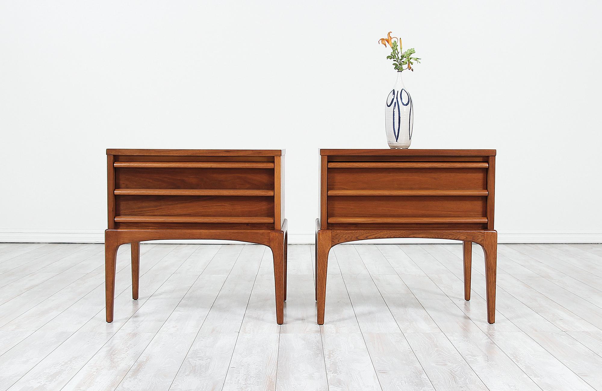 Pair of Mid-Century Modern night stands designed and manufactured in the United States by Lane Furniture, circa 1950s. This beautiful set of night stands feature a sturdy walnut wood case with a clean and minimalistic design and a big drawer with