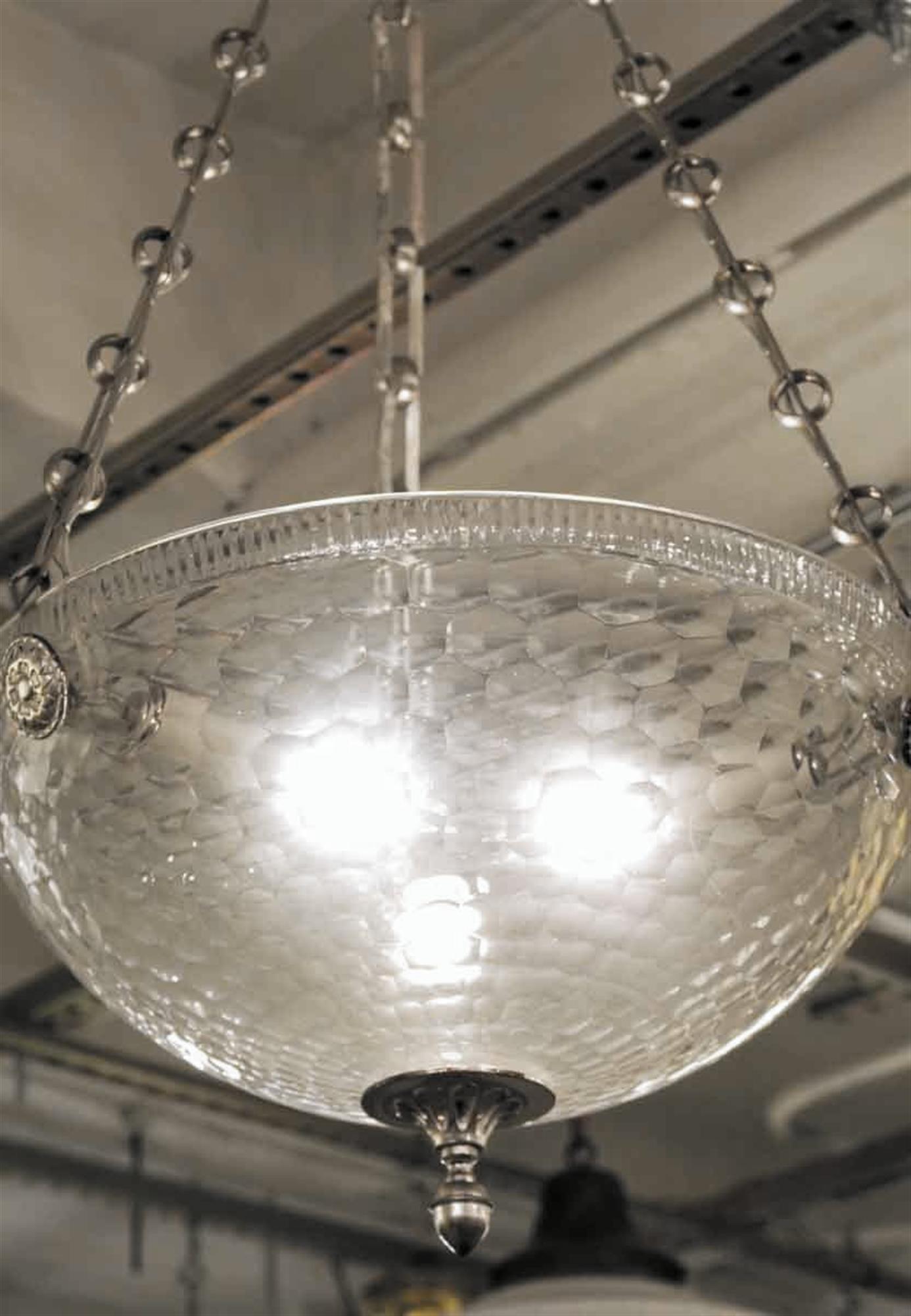 Mid-Century Modern style clear glass bowl pendant light with brushed nickel finished details and a unique chain. This can be seen at our 2420 Broadway location on the upper west side in Manhattan.