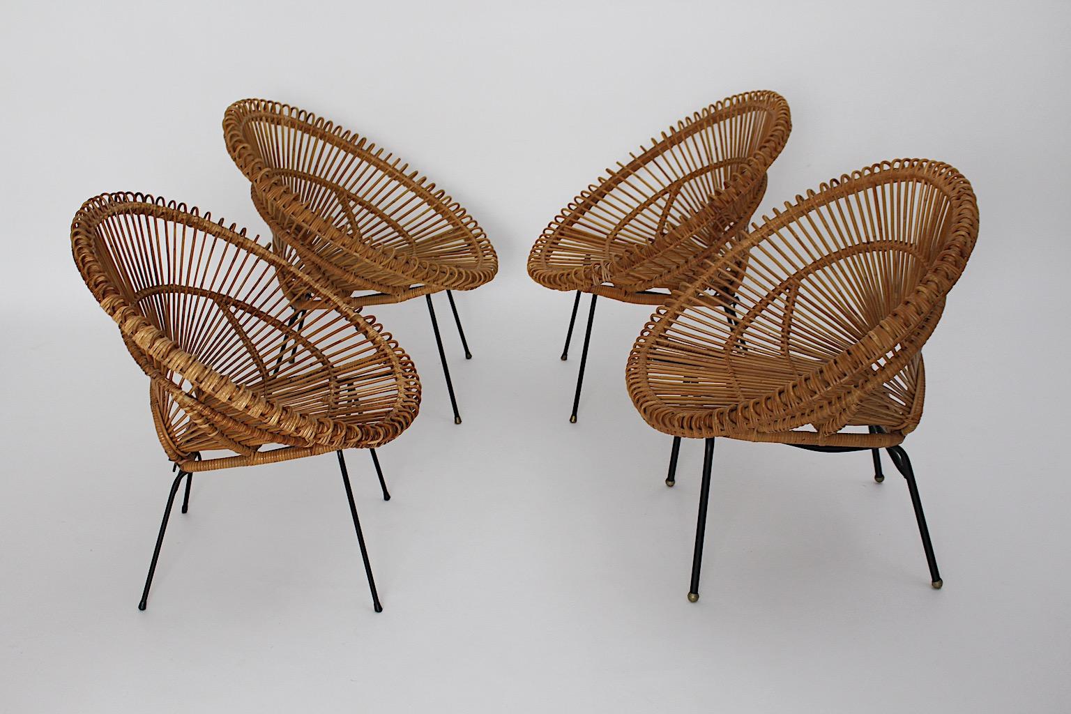 Mid-Century Modern Riviera style vintage patio set of four handmade lounge chairs from rattan
attributed to Janine Abraham and Dirk Jan Rol c 1960 France.
The handmade rattan lounge chairs show black lacquered metal base with rattan seat