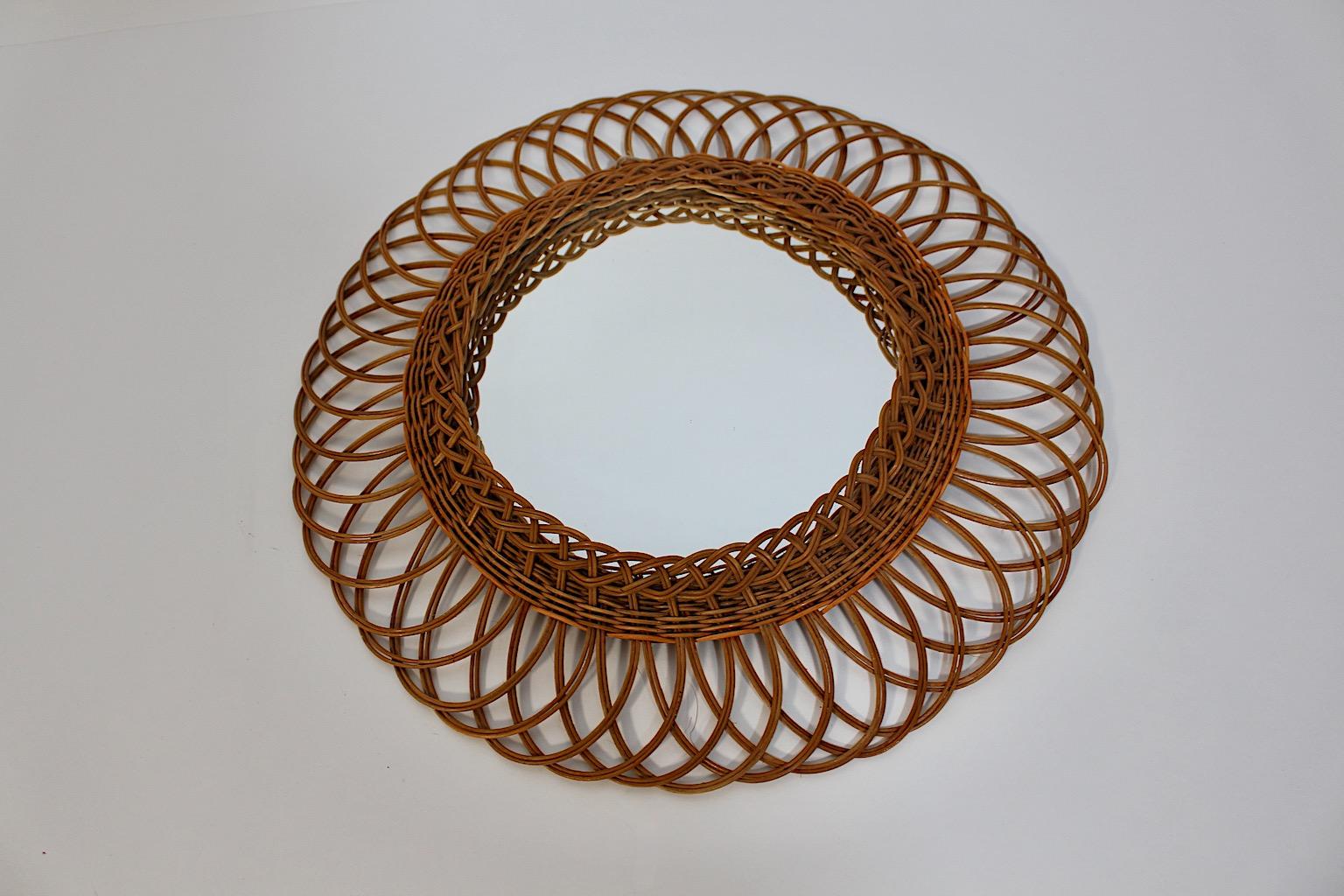 Organic Mid Century Modern Riviera Style vintage circular wall mirror or sunburst mirror from willow and mirror glass 1960s Austria.
A stunning circular like wall mirror framed with slightly curved willow sunburst like 
hand made 1960s Austria.
This