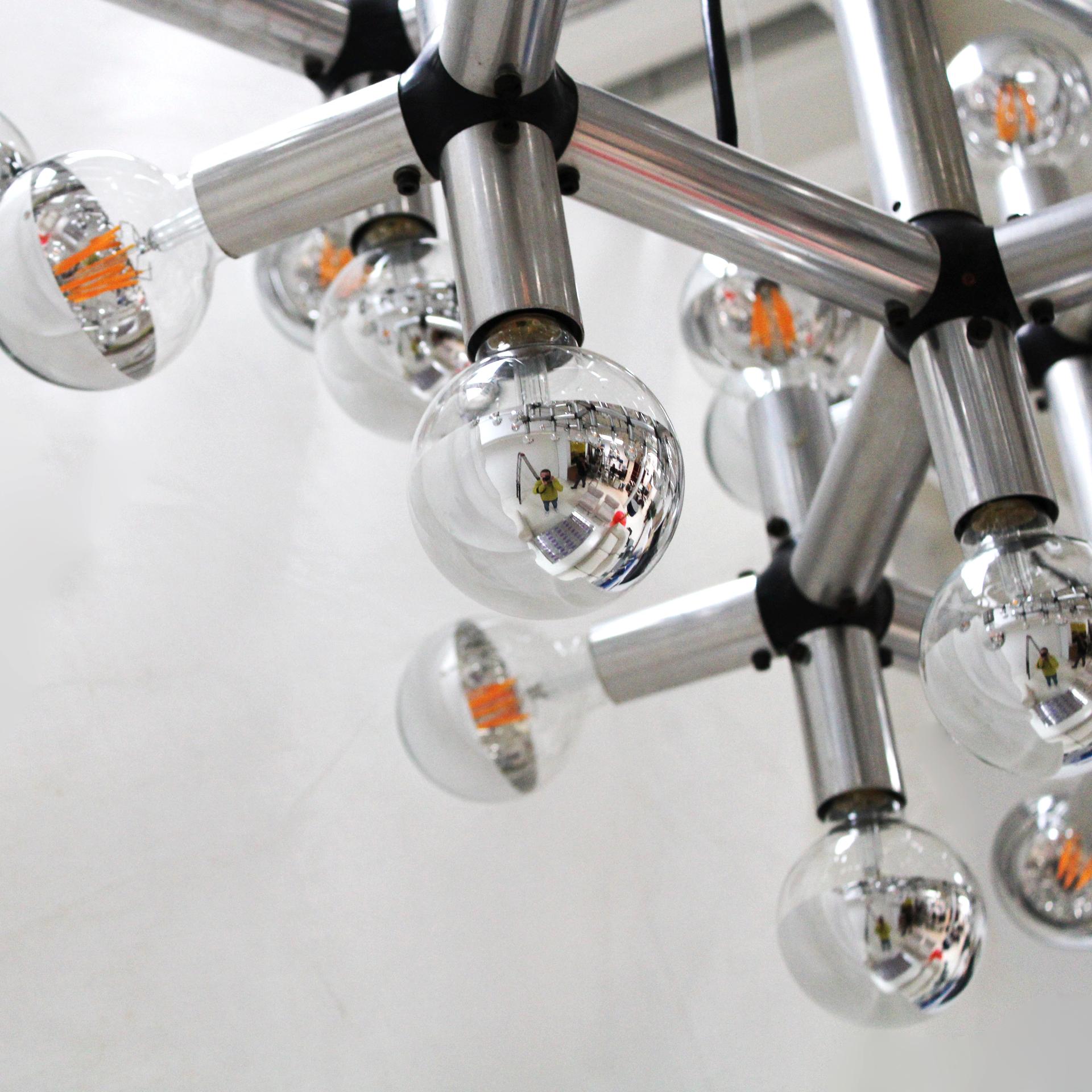Sculptural chandelier designed by Robert Haussmann and manufactured by Swiss lamp, Switzerland 1969. The lamp is made of aluminium tubes connected with black plastic connectors. The lamp is composed of 108 points of light

Discover the Atomic