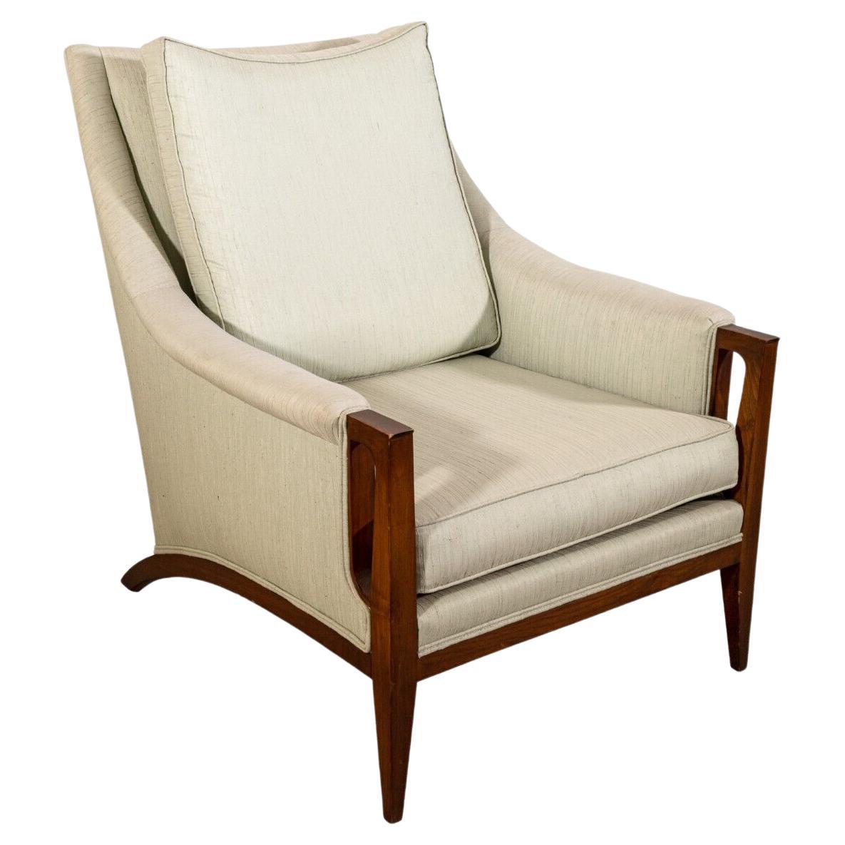 A Robsjohn Gibbings armchair and ottoman for Widdicomb. This fabulous lounge chair boasts an extraordinary silhouette, and a beautiful color combination. This armchair and ottoman combo feature a wood frame construction with a long arching curve