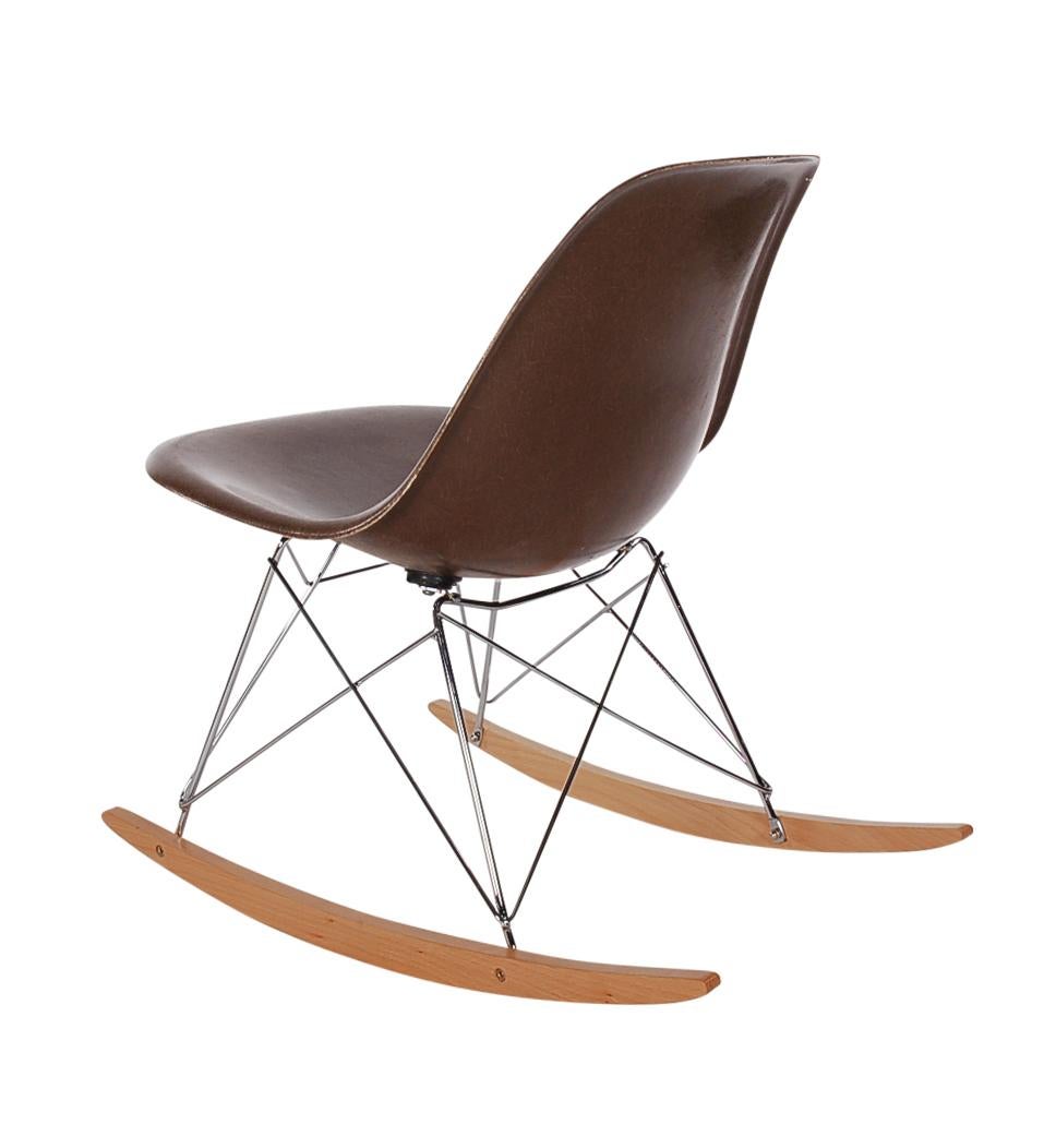 A beautiful chocolate brown fiberglass rocking chair designed by Charles Eames for Herman Miller. It features a vintage fiberglass shell chair on a newer production rocker base. Embossed manufacture logo on bottom of chair.