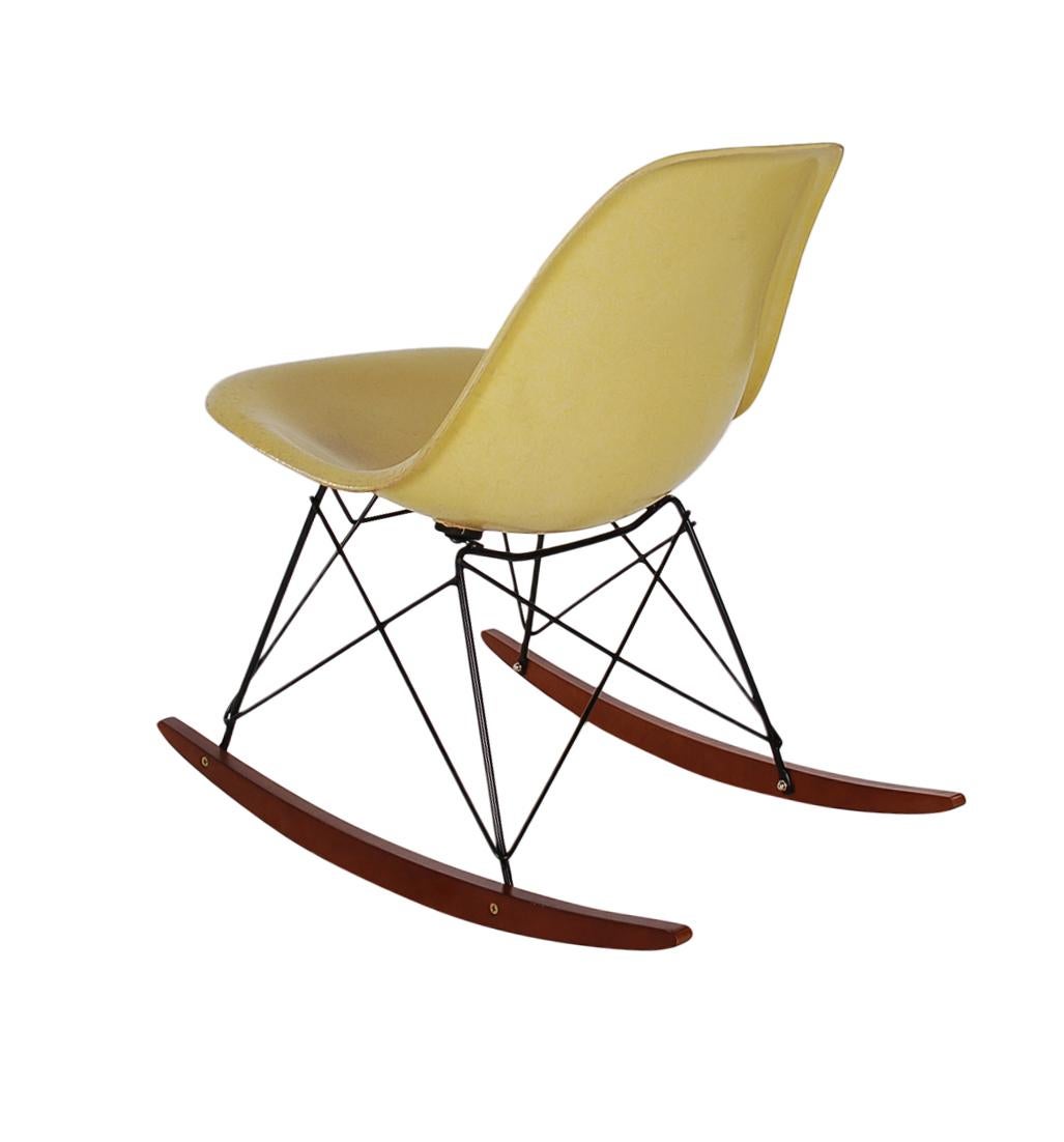 A beautiful pale yellow fiberglass rocking chair designed by Charles Eames for Herman Miller. It features a vintage fiberglass shell chair on a newer production rocker base. Embossed manufacture logo on bottom of chair.