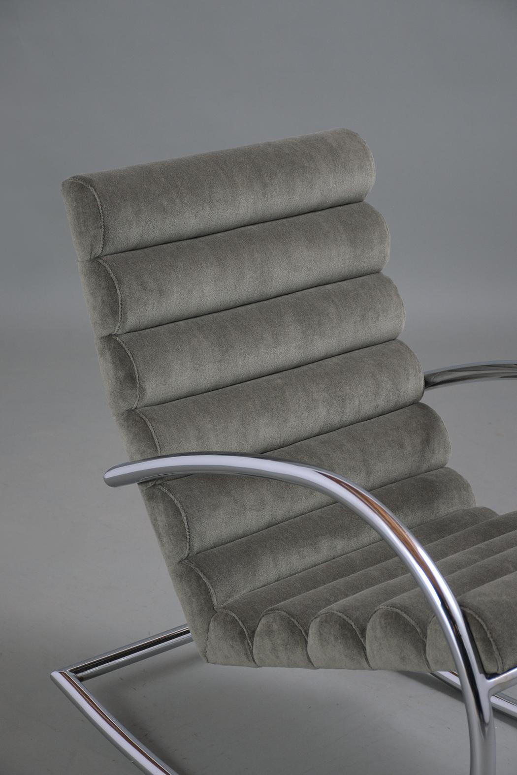 An extraordinary mid-century recliner chair crafted out of steel the chair has been professionally restored and newly reupholstered in a dark grey mohair fabric and new foam inserts with a channeled design. The chair rests on a polished curved