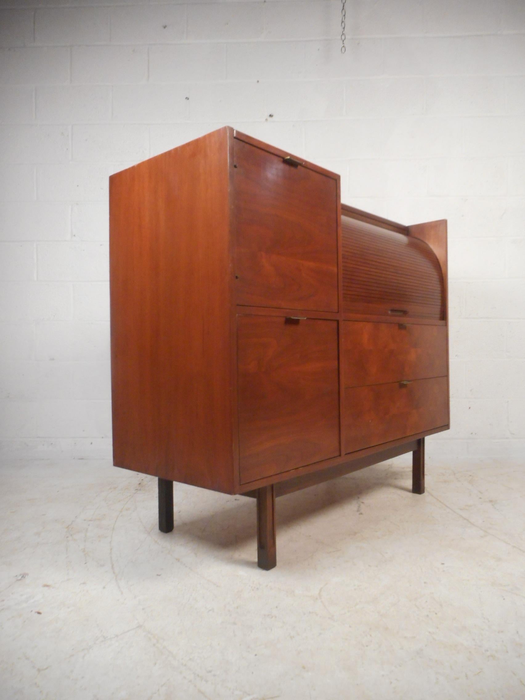 This beautiful vintage modern secretary desk features a tambour roll top that hides additional storage and a pullout / pull-out desk with a white laminate top. A functional design with an abundance of storage space within its many large compartments