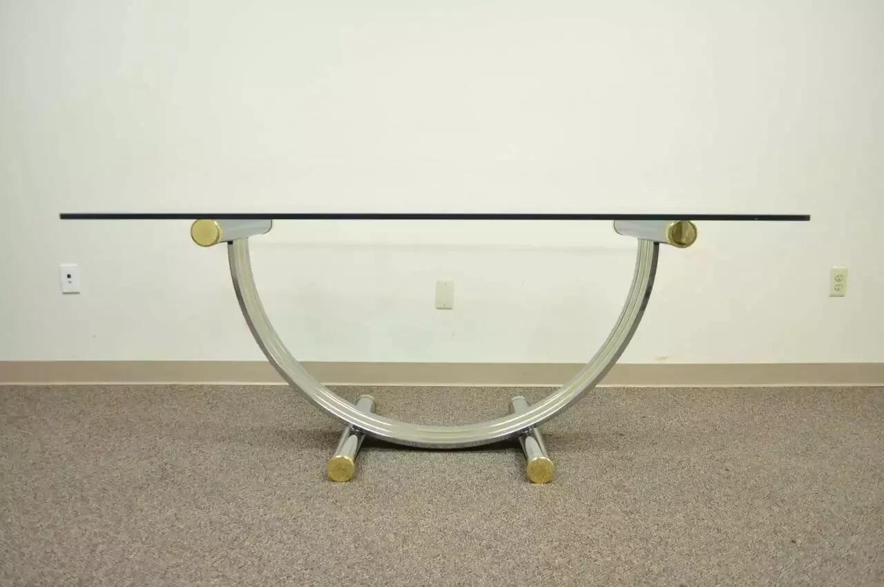 Table de salle à manger en forme d'arche en laiton chromé et verre, de style Romeo, du milieu du siècle dernier. L'article se caractérise par une base arquée avec des capuchons en laiton et un plateau en verre épais de 0,5