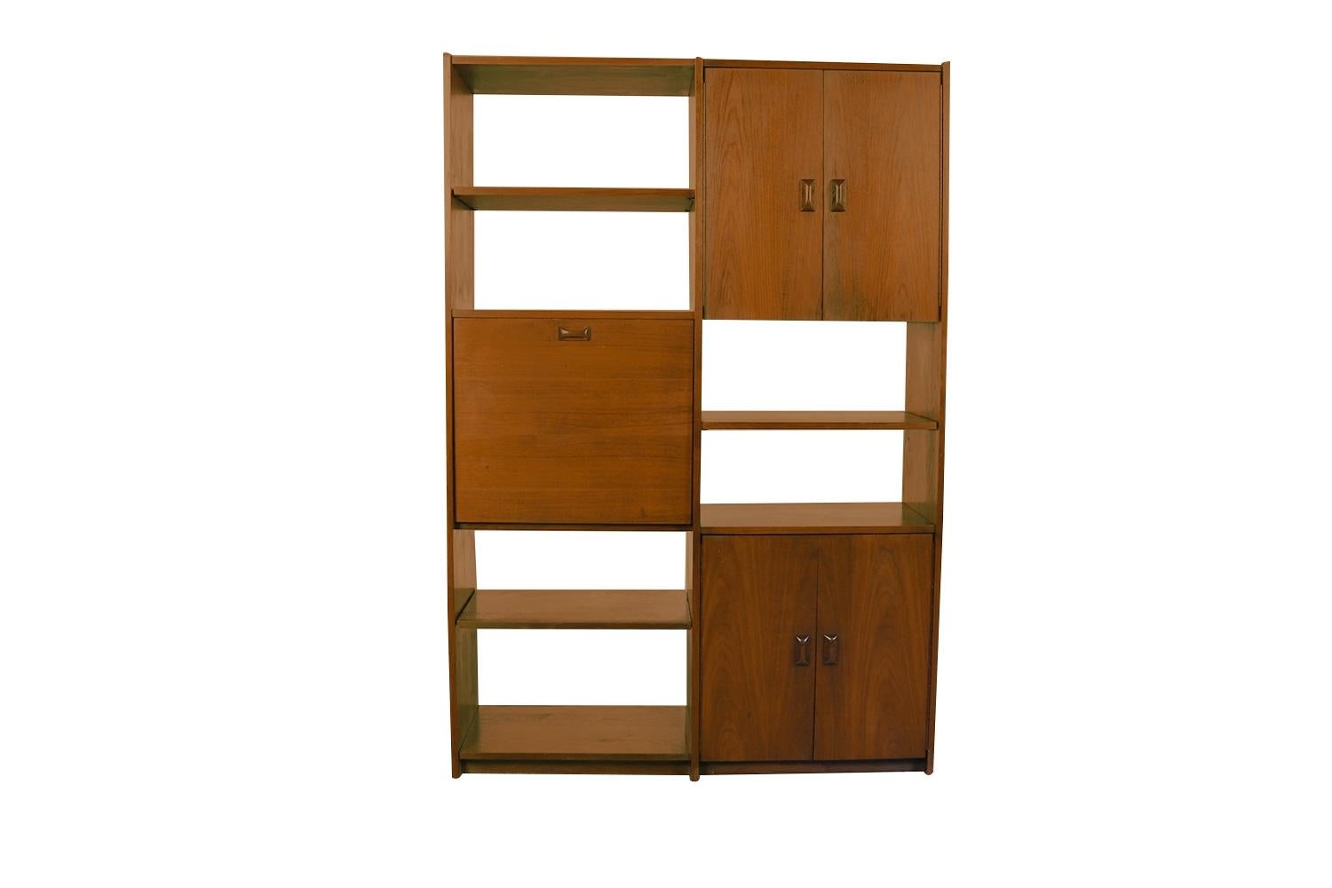 A remarkable two unit Mid-Century Modern, freestanding, room divider wall unit with a bar/desk, and cabinets, in nearly pristine condition. Built as a one-piece unit features gorgeous dark walnut tones and grain, with a fully finished back. The