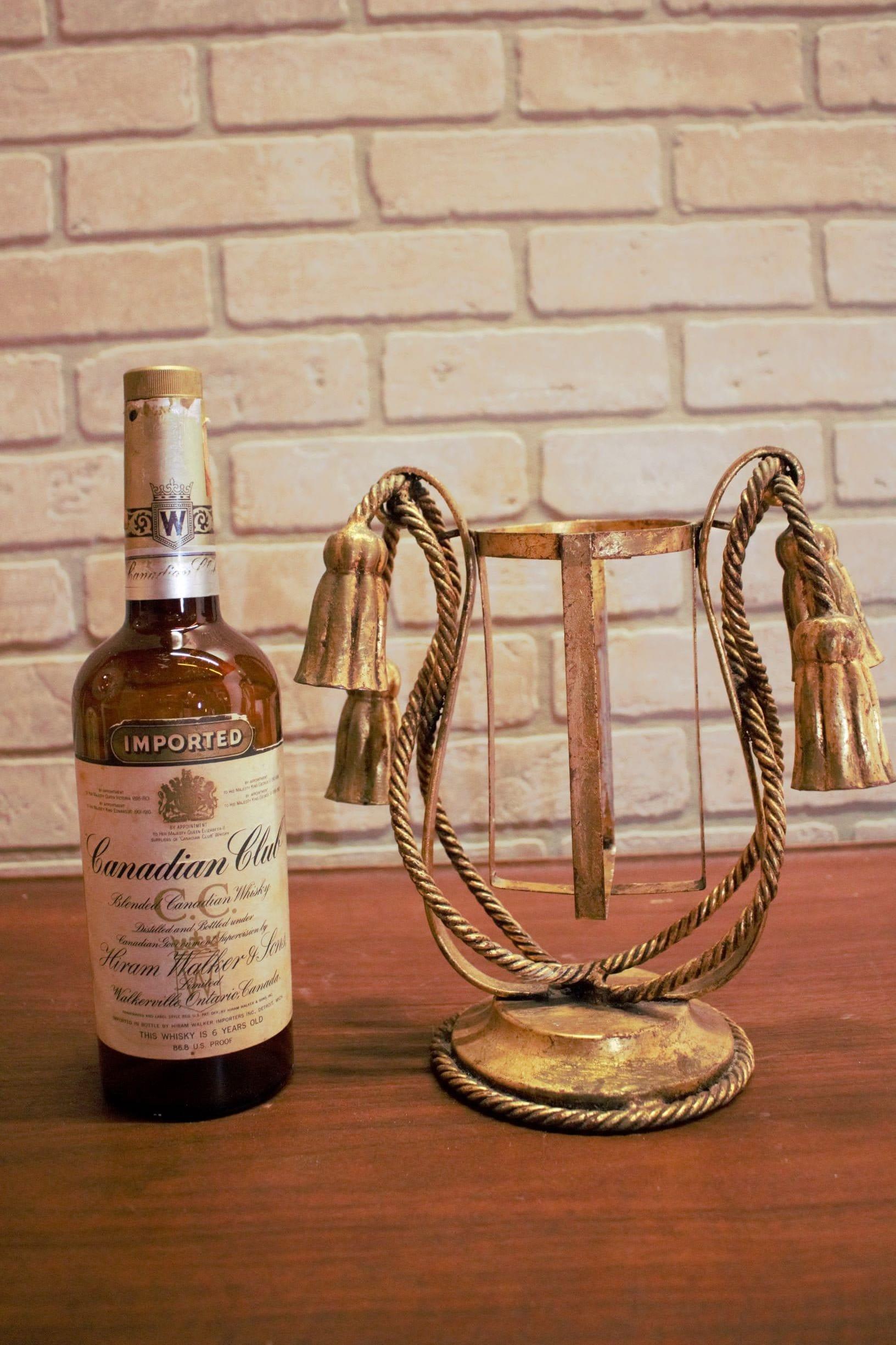 Mid Century Modern Rope and Tassel Bottle Holder

Featuring a vintage rope and tassel and gilt metal swirls with a 20th century design. Display your treasured wines with style while you entertain. Perfect for an in-home bar. 

Bottle not included.