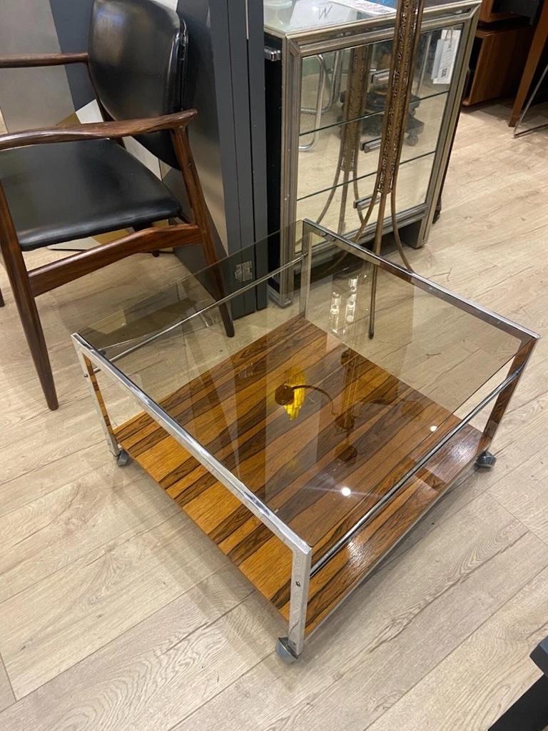 Table basse élégante du milieu du XXe siècle, créée par le designer américain Howard Miller pour MDA Products. Une véritable incarnation du design moderne du milieu du siècle.

Avec une riche base plaquée de bois de rose, complétée par des supports