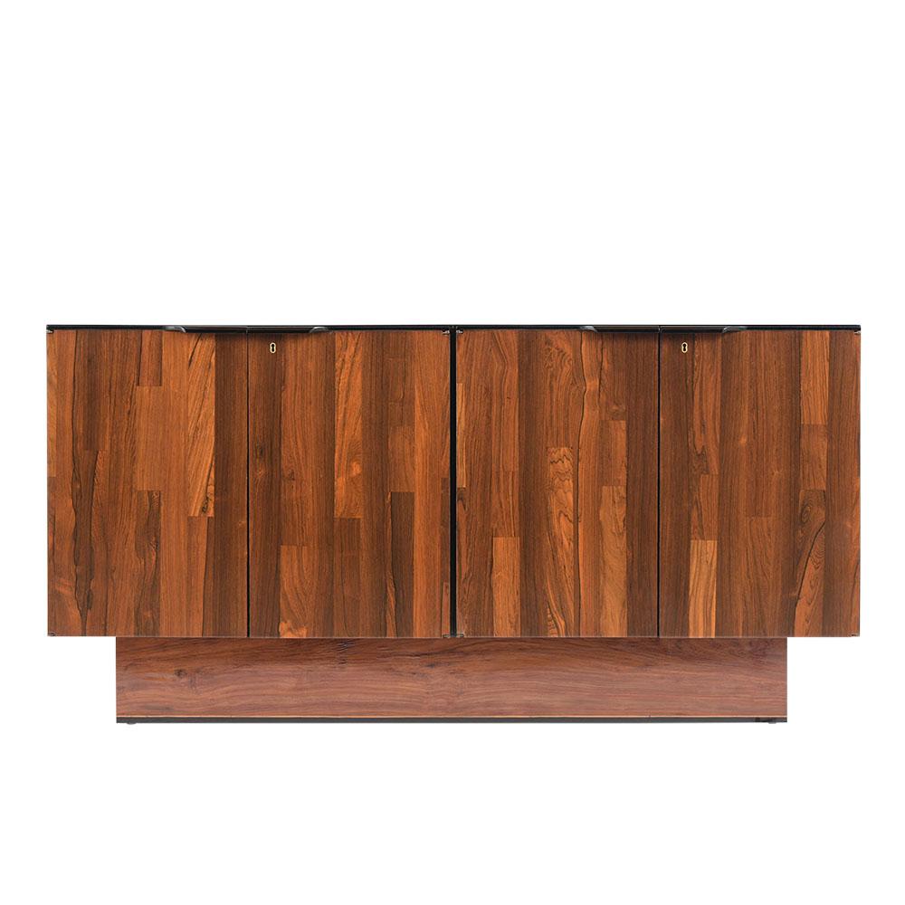 This Mid Century Brazilian Credenza by Barzhay has been fully restored, is made out of rosewood, and finished in a rich dark mahogany & black color combination with a newly lacquered finish. The sideboard comes with four doors with large carved-wood