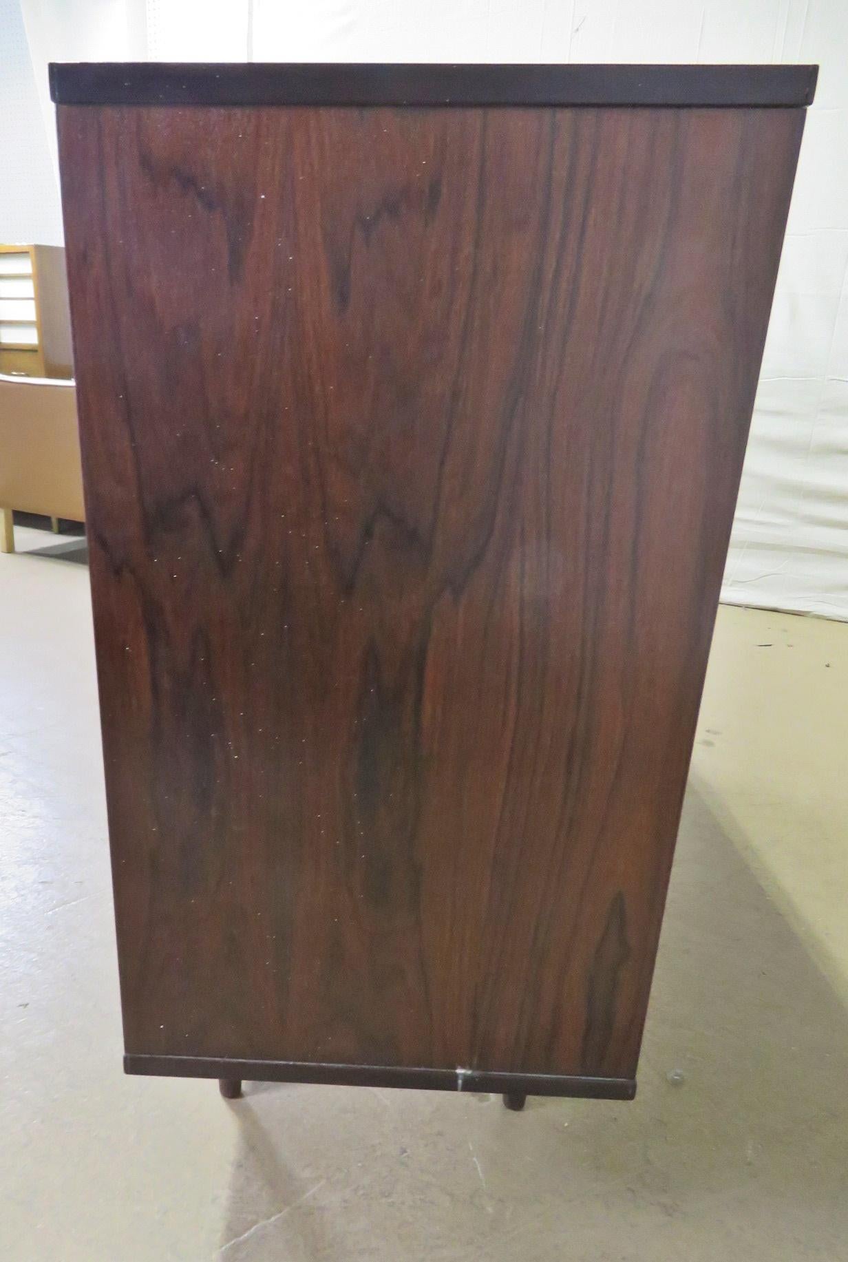Mid-Century Modern rosewood credenza with 2 doors containing 2 files and 1 shelf.