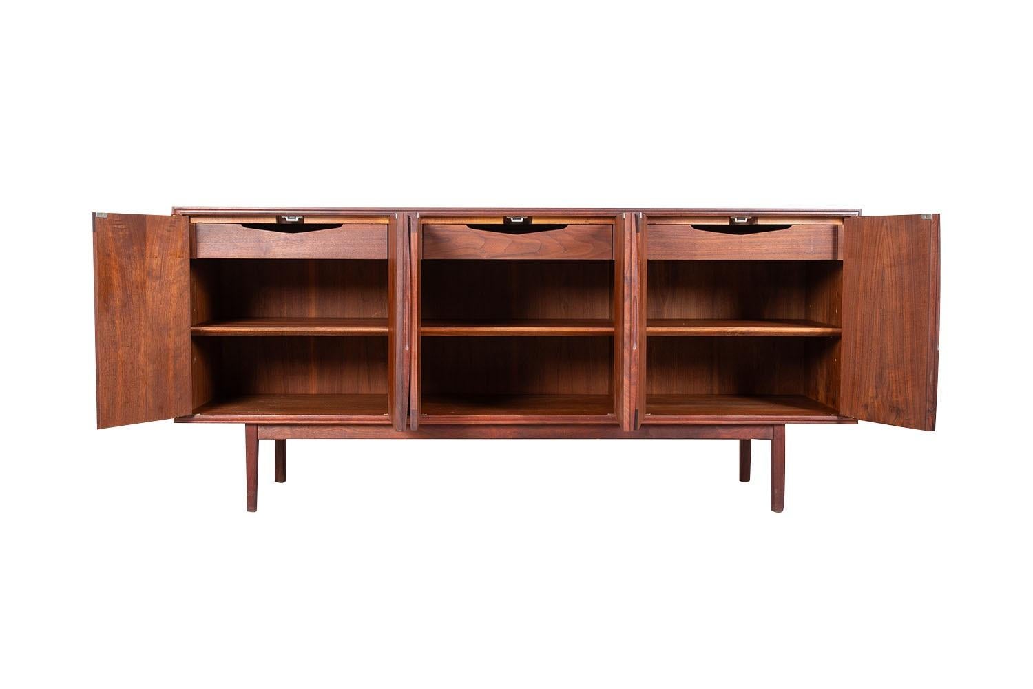 Credenza/seduta in legno di palissandro di epoca moderna, circa 1960. Questa credenza, realizzata in modo intelligente, è una perfetta collaborazione tra design e funzionalità. Le porte dell'armadio sono triple e si aprono per rivelare tre vani con