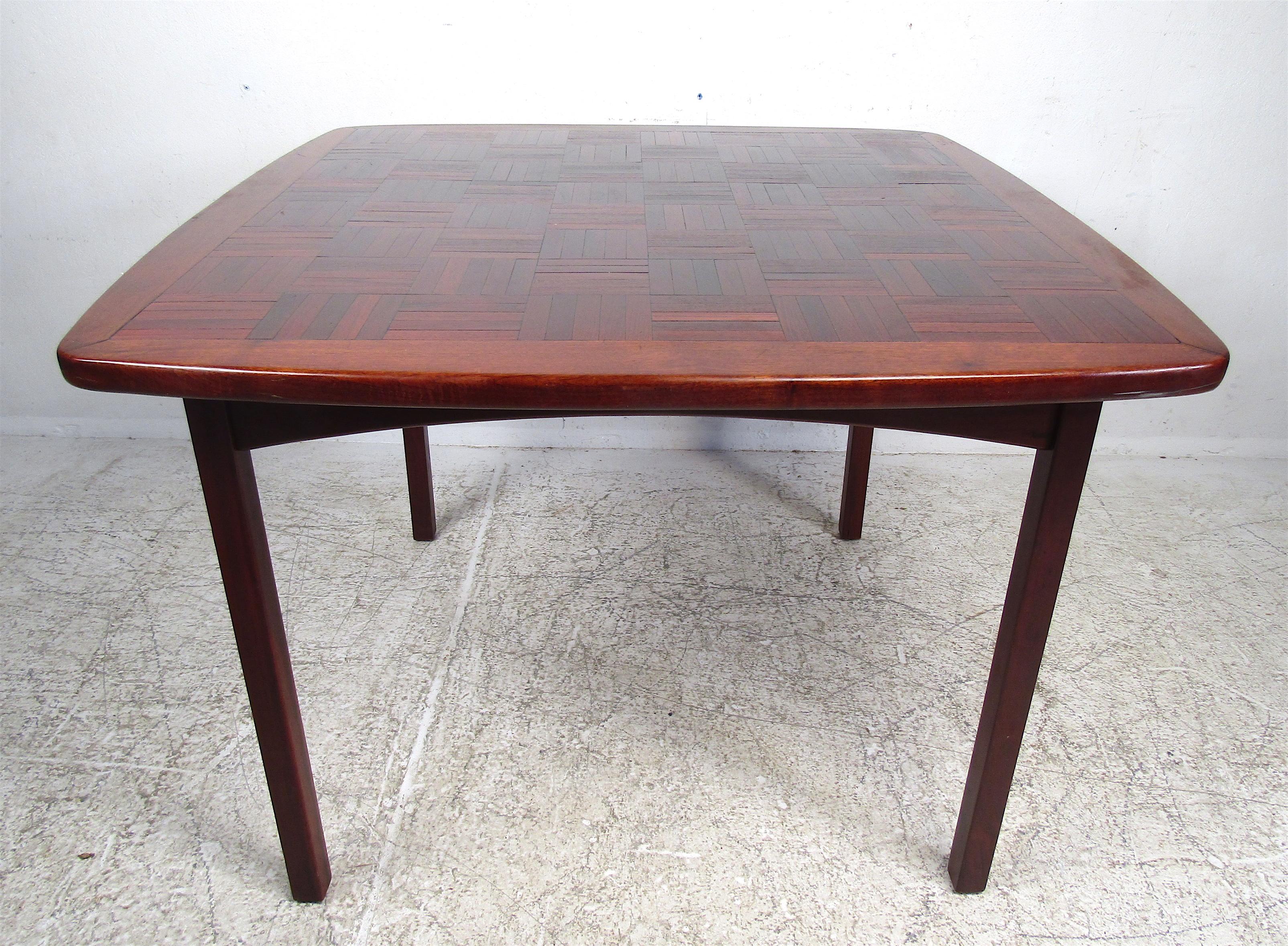 This stunning vintage modern rosewood kitchen table features an unusual mosaic top. A beautiful two-tone design with long legs and rounded edges. This is an original 1960s piece with the date stamped April 21, 1966, underneath. This versatile and