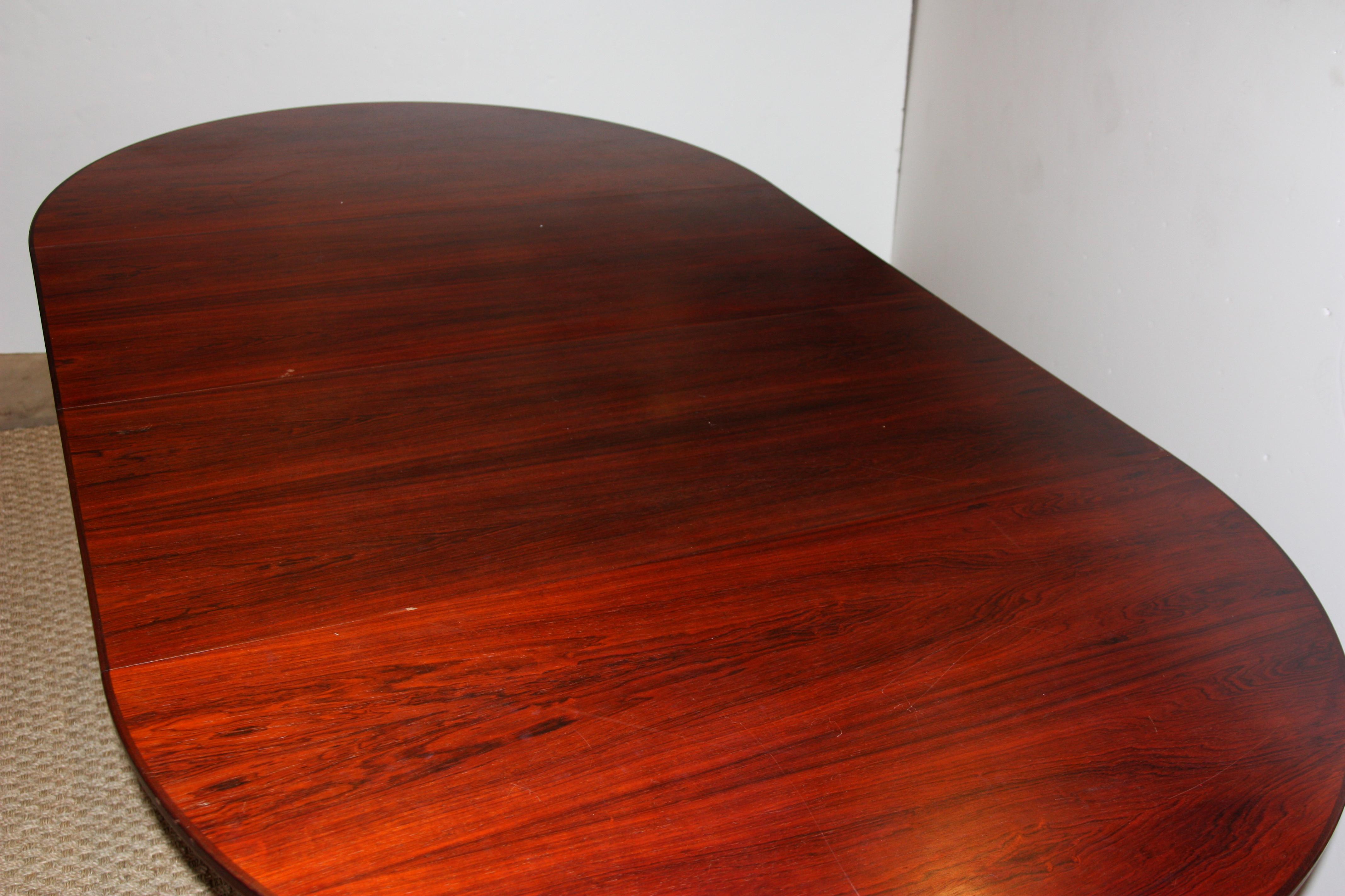 Mid-Century Modern dining table in original vintage condition. This table has two leaves that allow the table to be expanded or reduced in size.