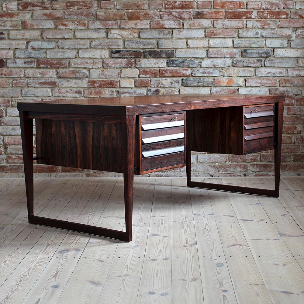 This stunning vintage rosewood desk is a fantastic example of Kai Kristiansen style, one of the most-appreciated Danish designers of 20th century. Pure in form yet very effective. The desk features two spacious dual-sided storage sections. On one