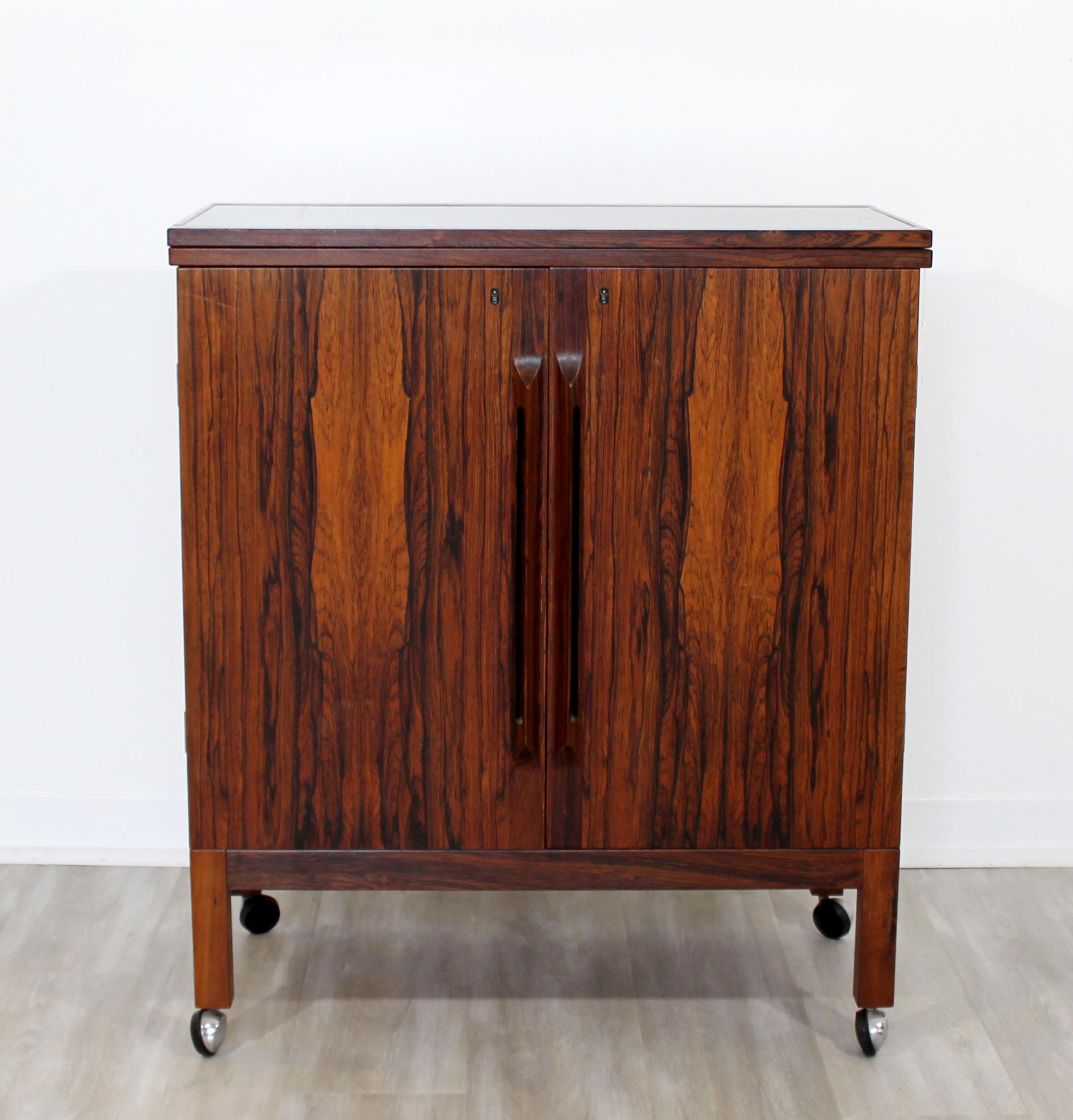 For your consideration is a magnificent, rosewood bar cart, with a black flip top, on casters, designed by Torbjorn Adfal, circa the 1960s. In excellent condition. The dimensions are 30