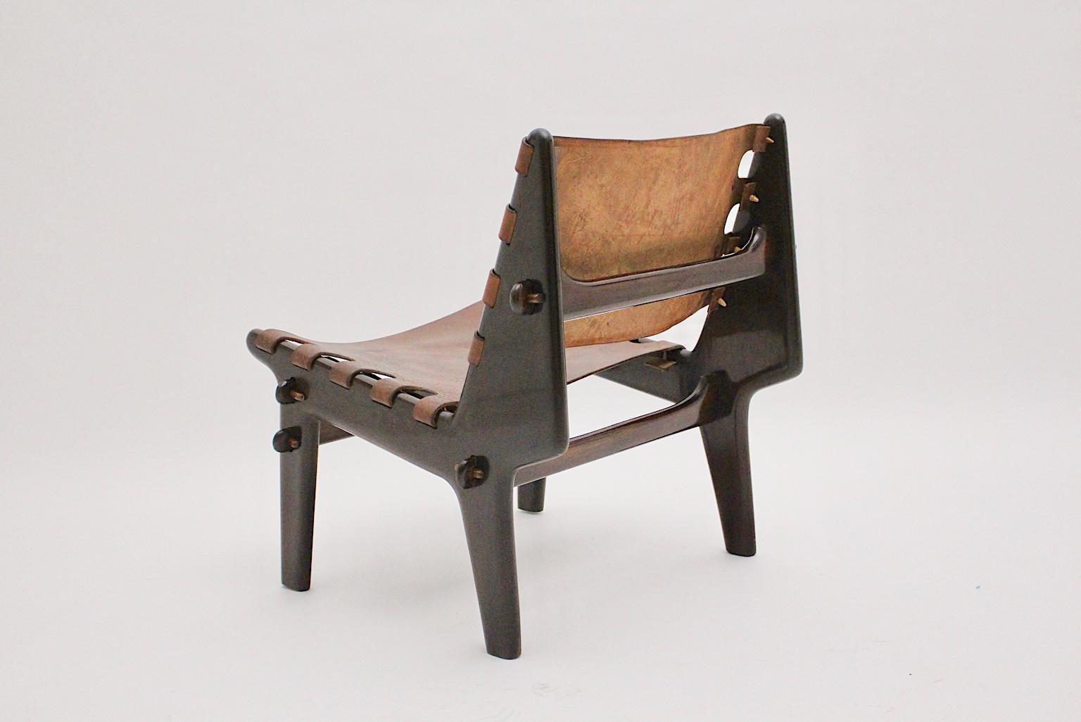 Mid-Century Modern lounge chair from stained beechwood and thick leather, which was designed by Angel Pazmino, 1960s.
The lounge chair has been taken apart and completely cleaned and professionally polished by hand before reassembly.
The seat and