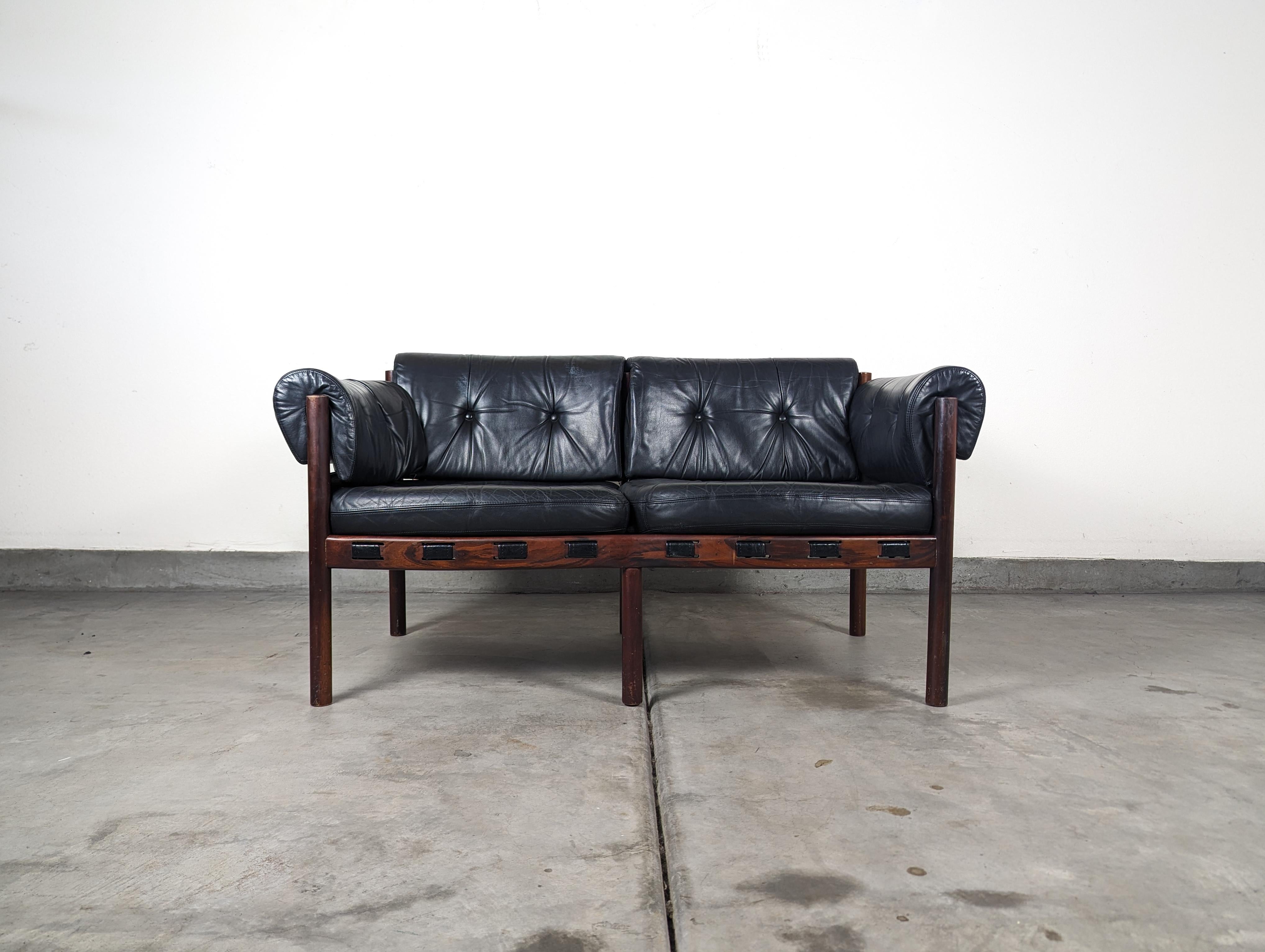 Presenting for sale, an iconic, rare, and highly sought-after mid-century modern loveseat designed by the legendary Swedish designer, Arne Norell. This exquisite piece originates from the 1960s

This particular version is fashioned from luxurious