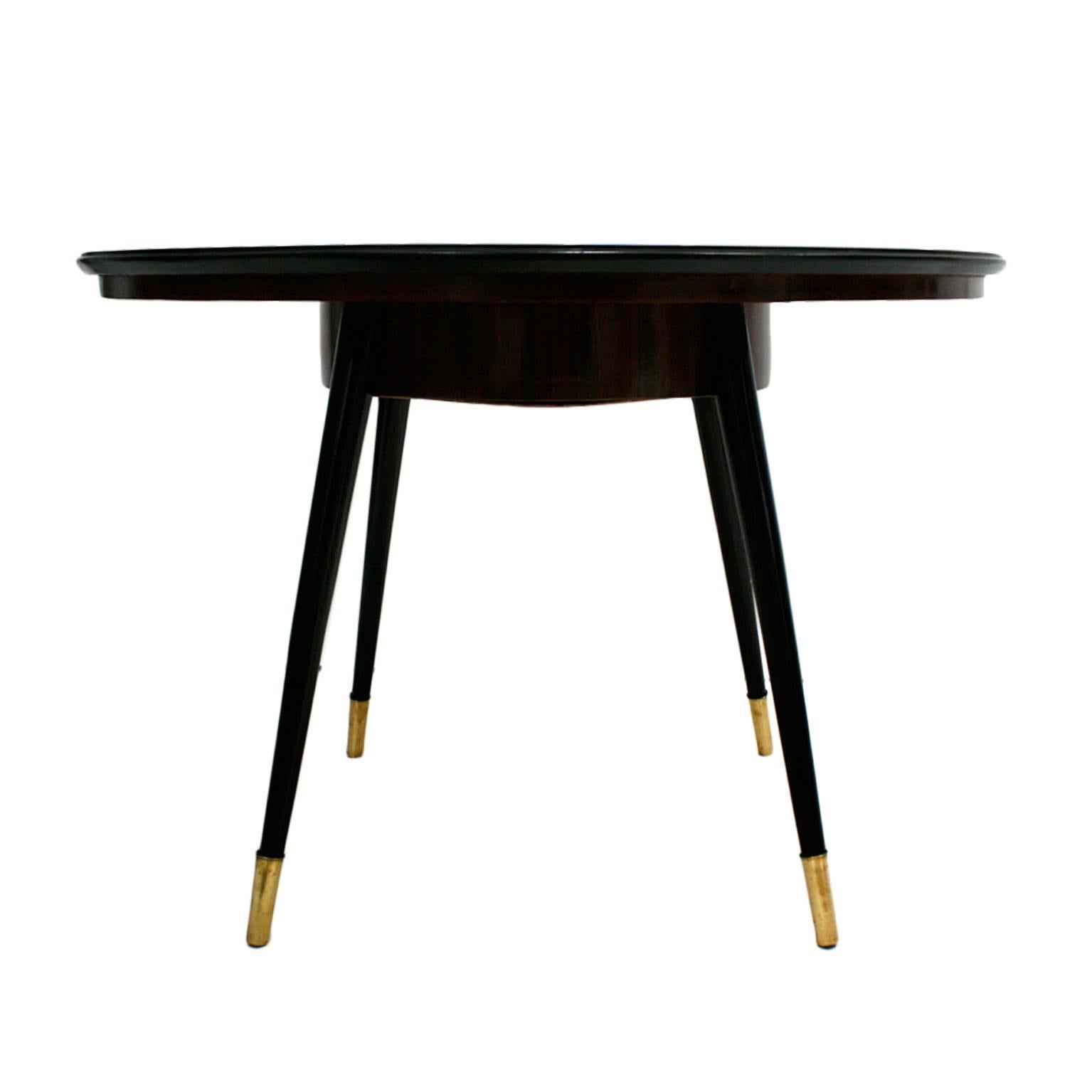 Circular pedestal table composed of rosewood marquetry top and conical legs with brass details.
 
 