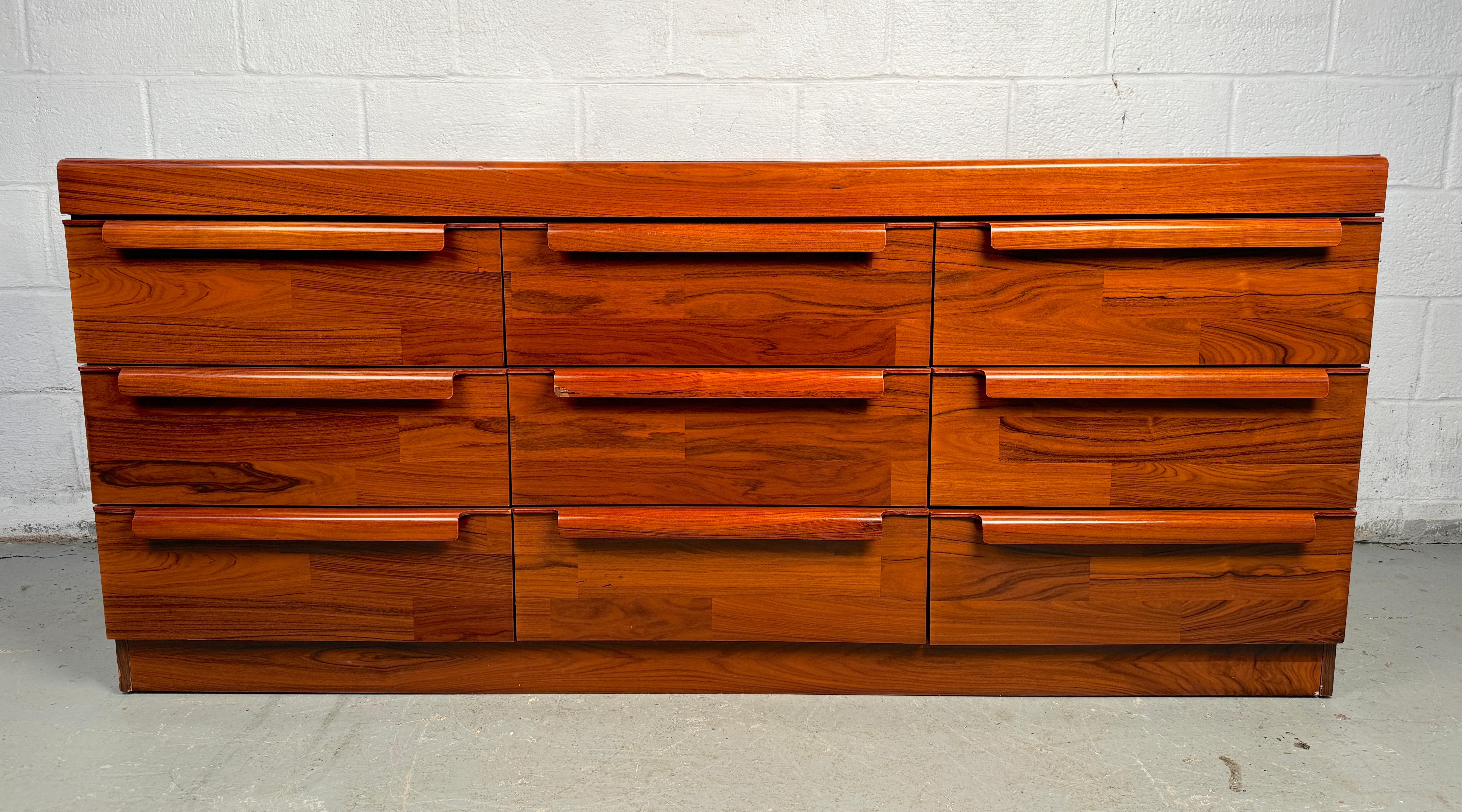 Aggiungi un tocco di eleganza e bellezza funzionale alla tua casa con questo comò a nove cassetti in legno di palissandro in stile Mid-Century Modern. Un mix perfetto di design elegante, conservazione funzionale e bellezza naturale. Realizzata in
