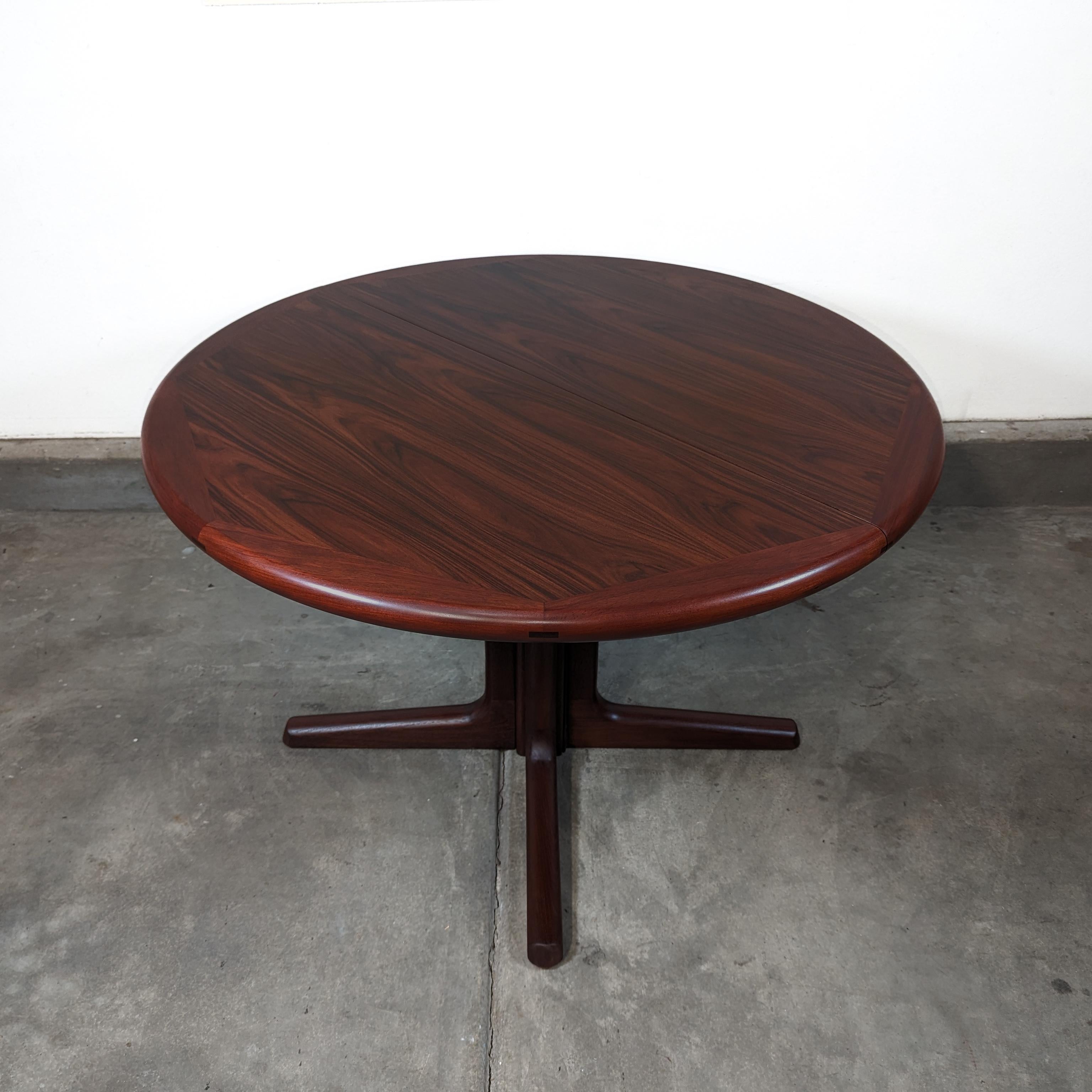Transform your dining area with the exquisite vintage mid century modern rosewood pedestal dining table by Dyrlund from Denmark, dating back to the 1960s. This meticulously restored piece exudes timeless elegance and sophistication, showcasing the