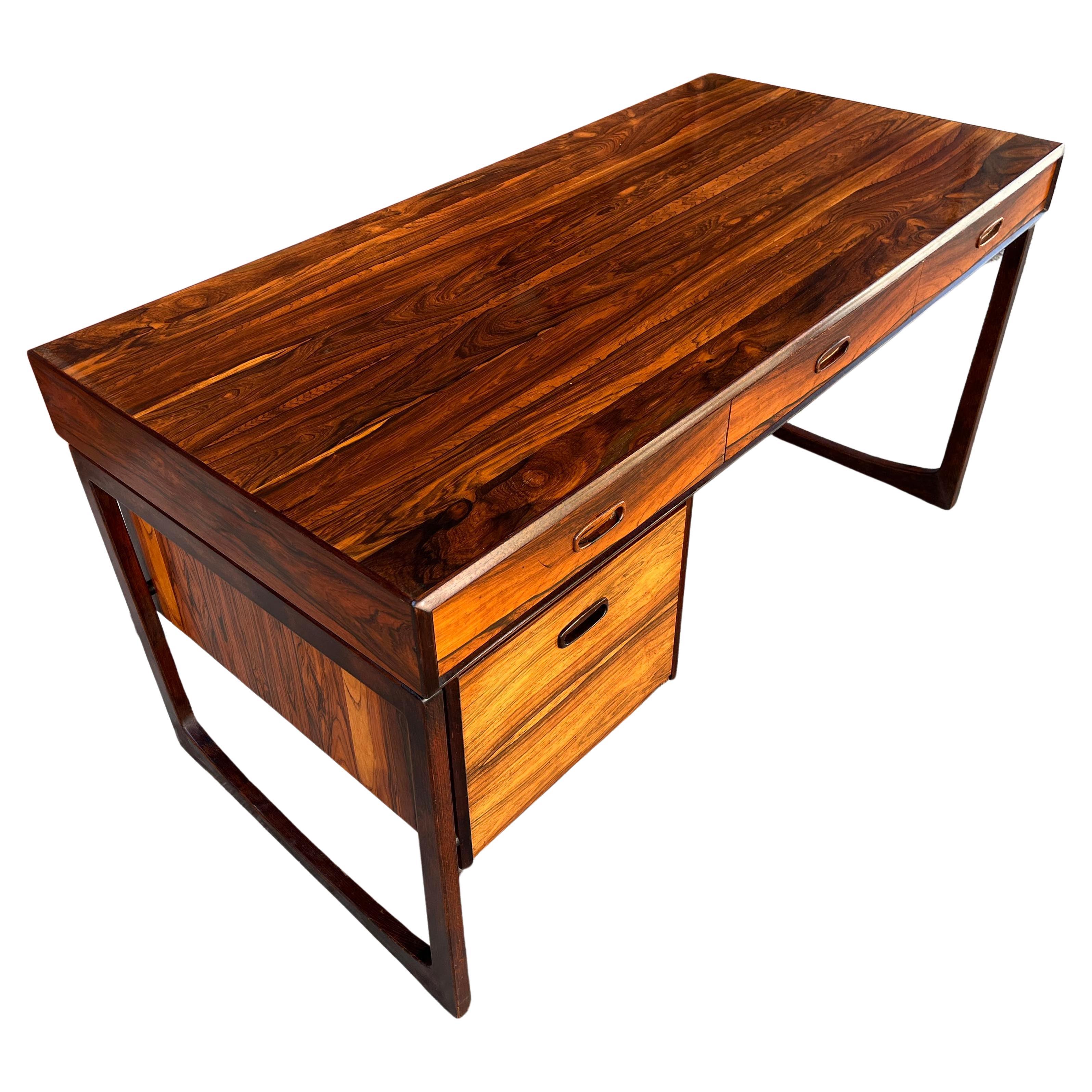 Stunning 1970s modern rosewood desk by Ganddal Mobelfabrik, in vintage original condition. Rich, vibrant tone and grain with intense color and contrast. Floating top and finished back with built-in book shelf. Fine vintage condition with all