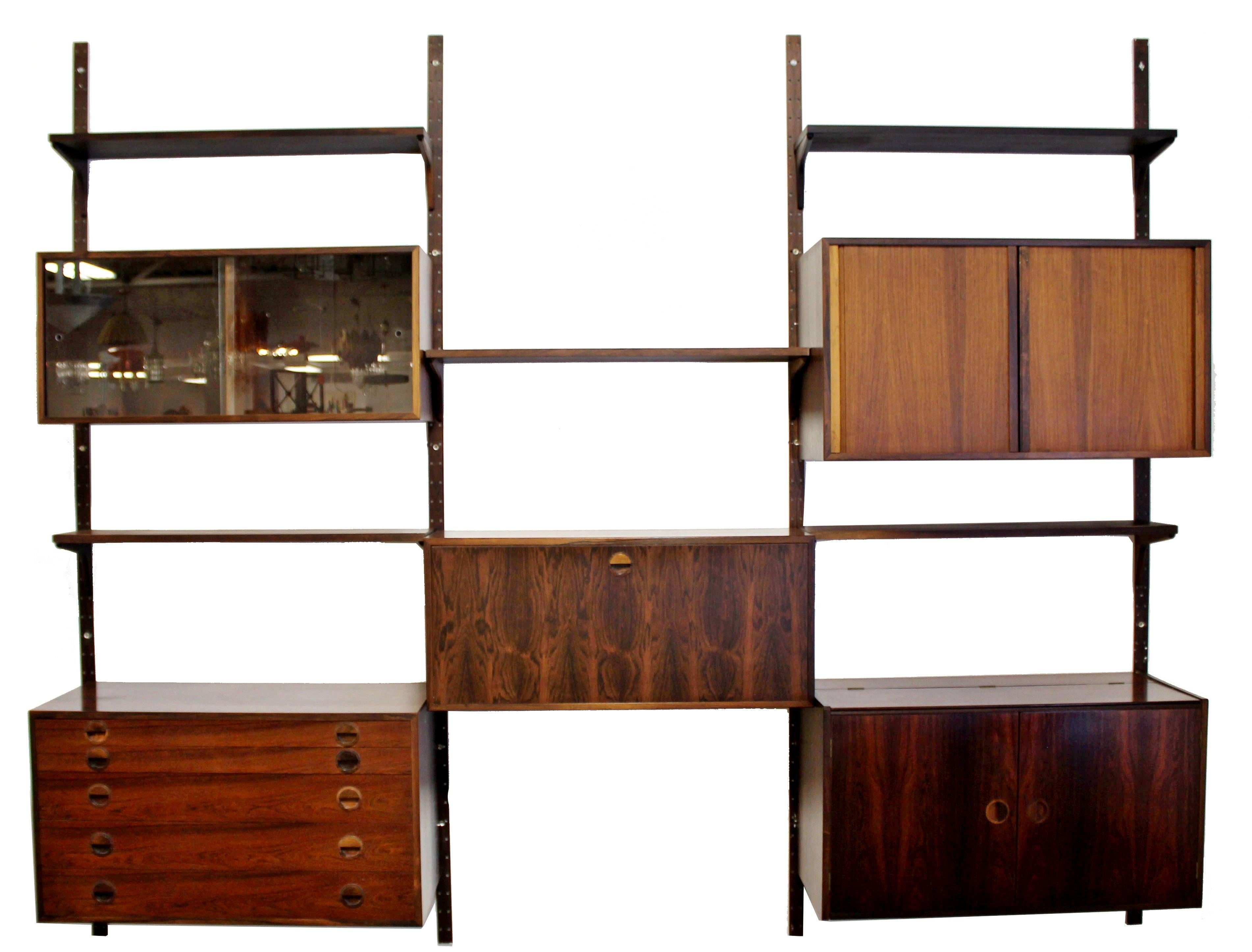 For your consideration is an utterly fabulous, rosewood, mounted wall shelving unit from Denmark, circa 1960s. Possibly attributed to Poul Cadovius. In excellent condition. The dimensions are 107