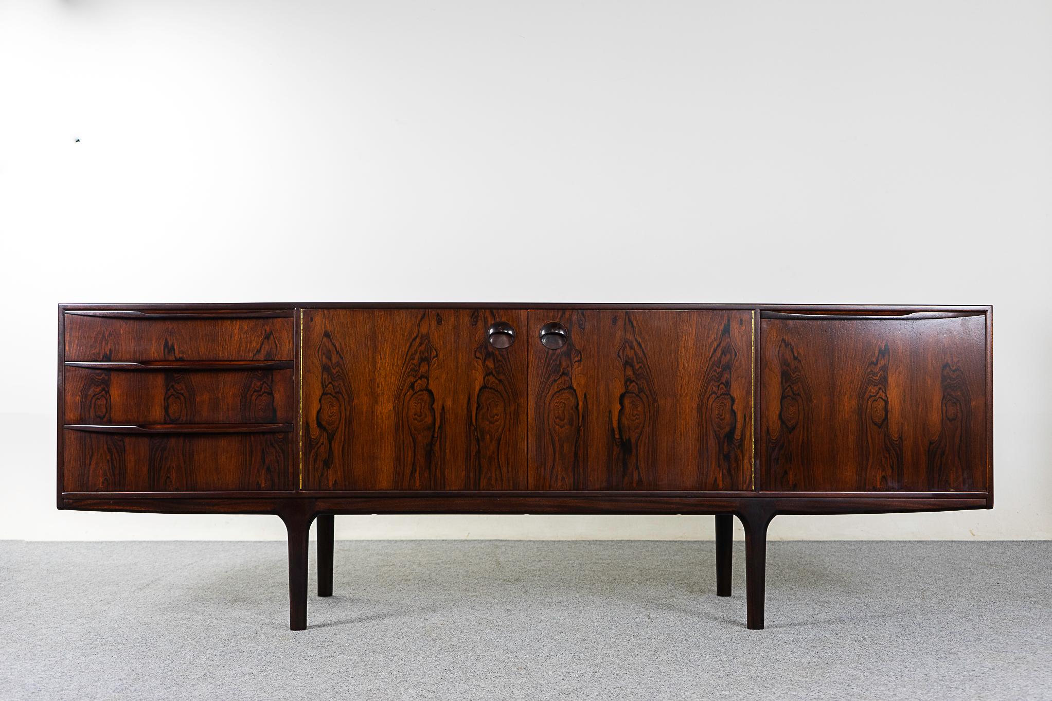 Rosewood sideboard by McIntosh, circa 1960's. Clean, simple lined design highlights the exceptional book-matched veneer. A combination of sliding doors, exterior drawers and a drop down front offers ample storage. McIntosh makers' mark intact.