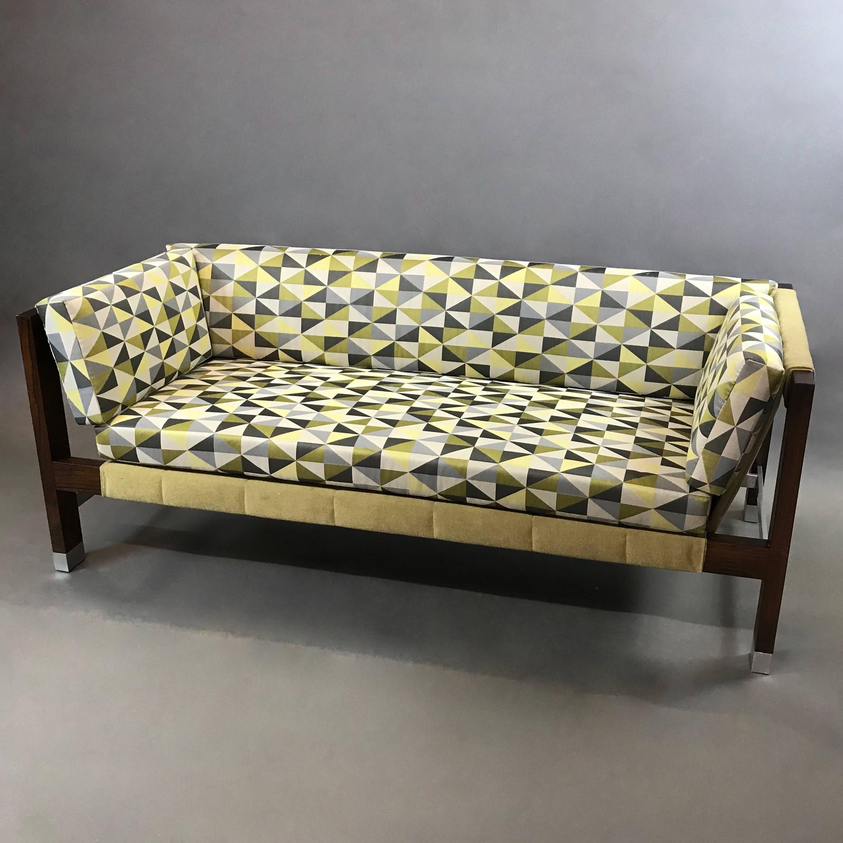 Mid-Century Modern, low-profile, two-tone, sling sofa by Jack Cartwright features a rosewood and aluminum frame with chartreuse mohair sling and contrasting greens, grays and white, op-art patterned, linen cotton blend cushions resting in the sling.