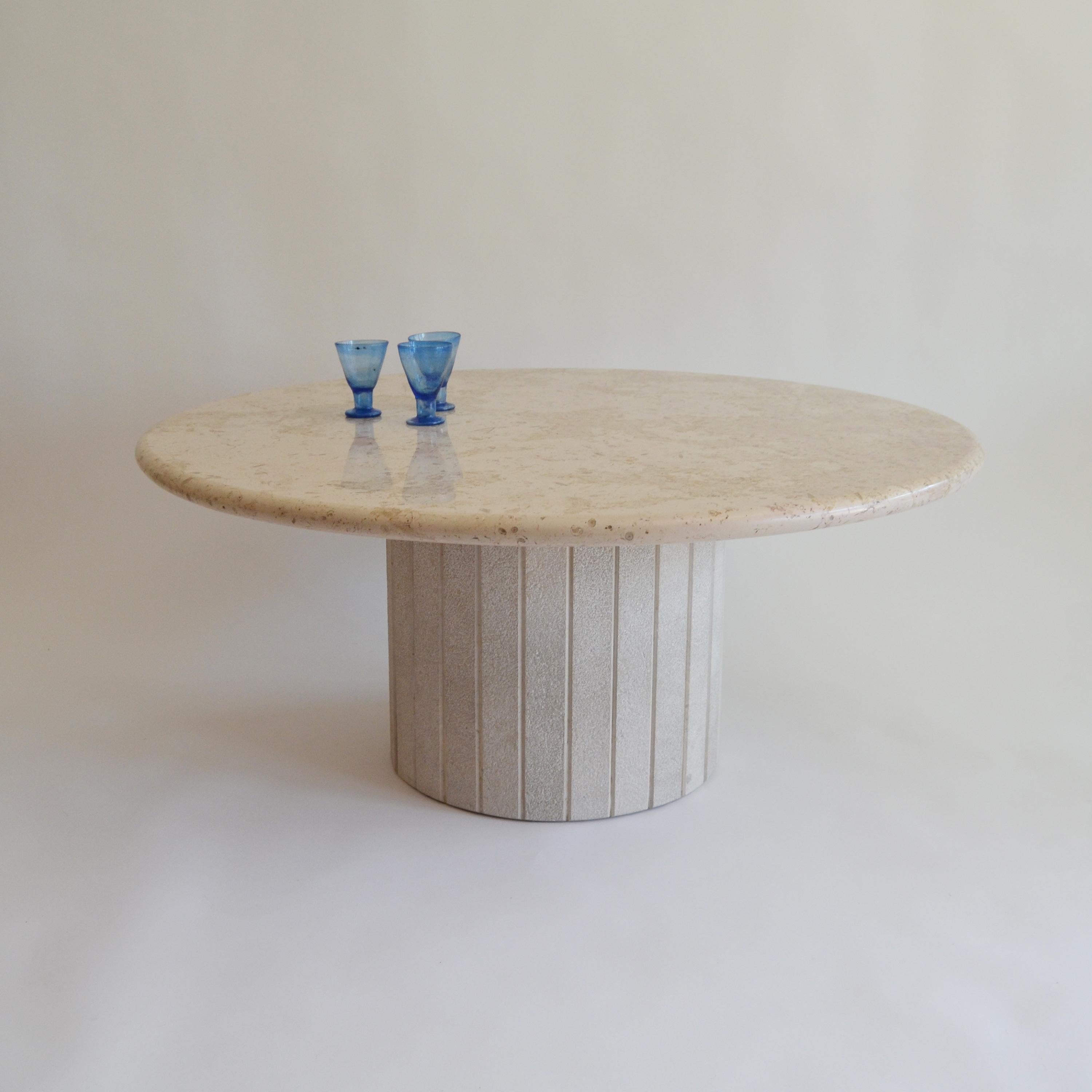 Mid-Century Modern round travertine coffee table. 
Nice pedestal table, made in Italy in the seventies. 
The leg has typical panelled lines, also in travertine.
The tabletop is in pristine condition, as the leg.
  