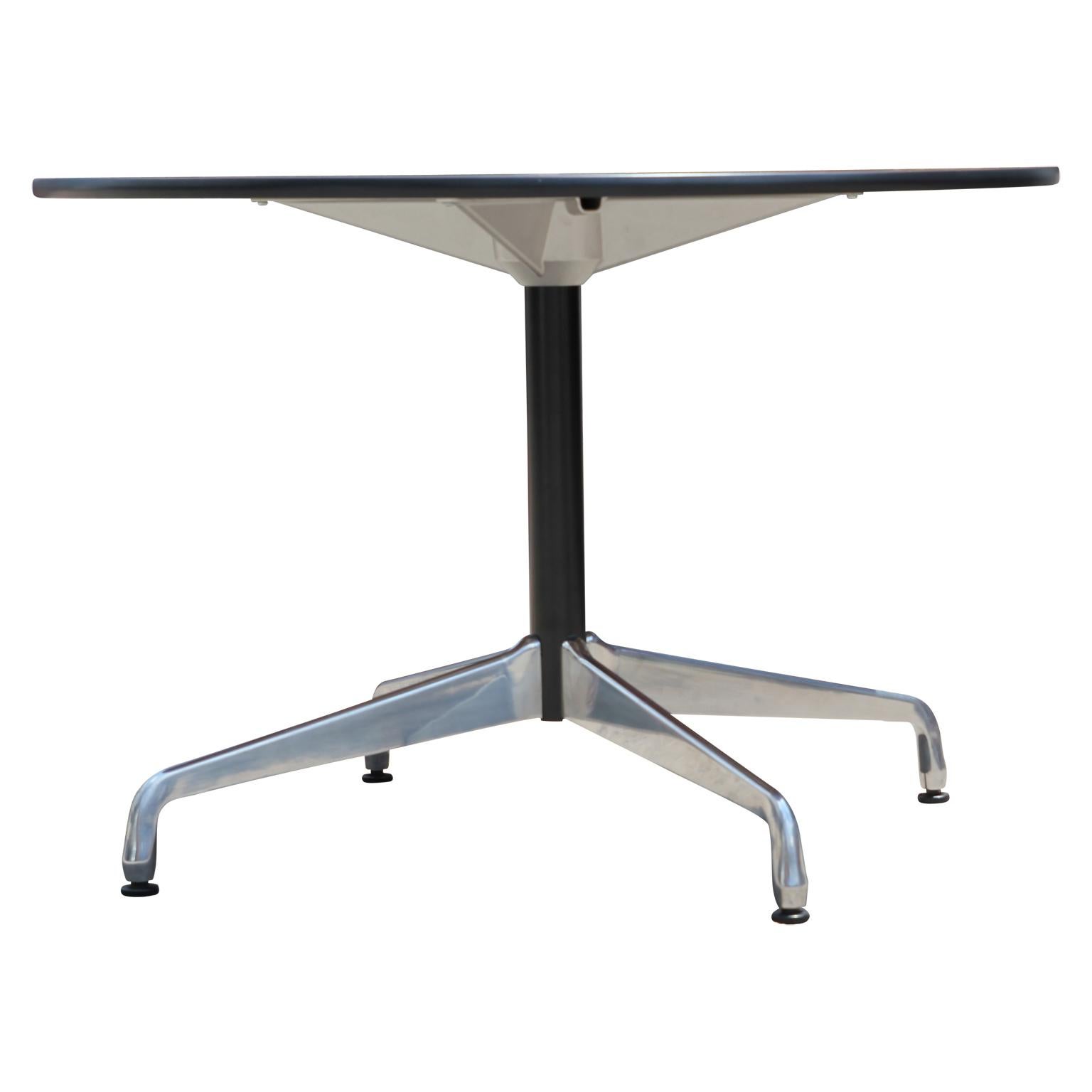 Mid-Century Modern round office table or dining table with a durable chrome base designed by Eames. The table has a dark wood top.