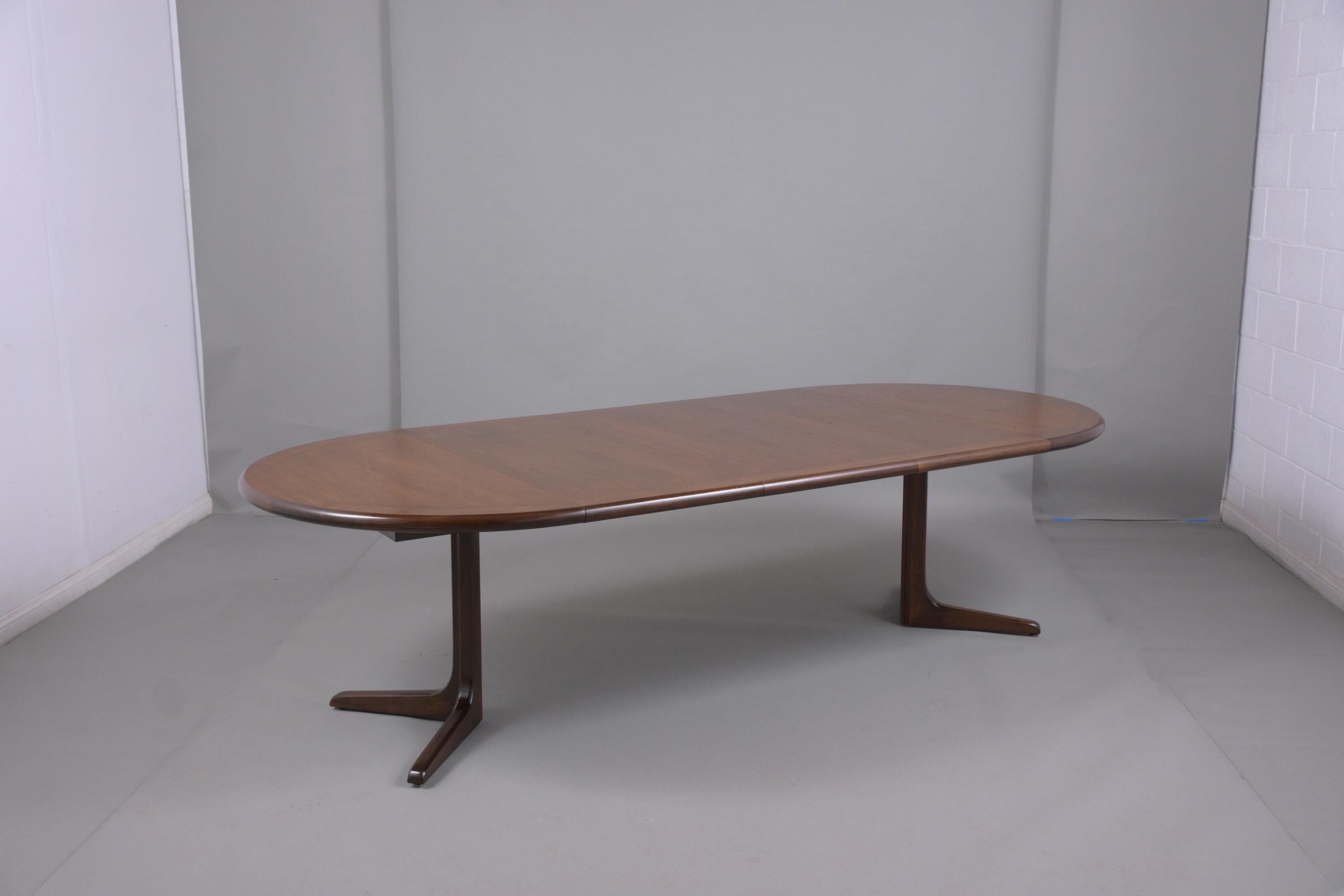 This Danish mid-century modern dining table has been newly restored, is made out of teak wood, and has its natural walnut stain finish with a newly lacquered finish. This circular top table comes with three extra leaves that can be added/ removed